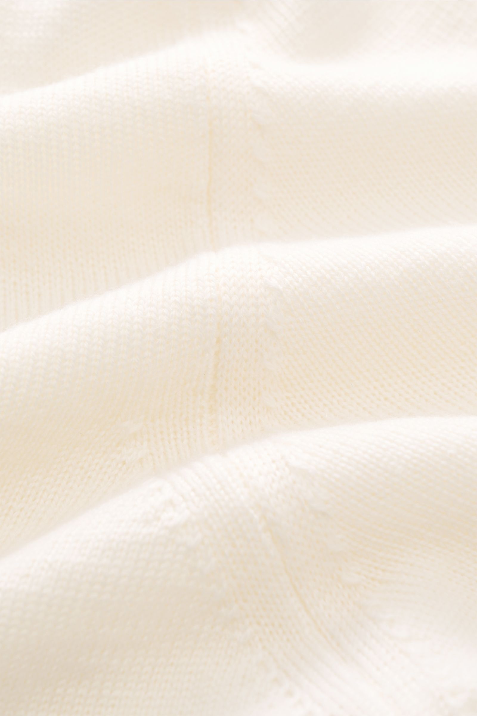 Close-up front view of Aurélien Kurzarm-Strickpolo 'Cashwool' offwhite showcasing fine knit texture, soft pure Merino wool, slim fit, classic polo collar, open placket, and comfortable ribbed cuffs, a spring essential with exclusive cashwool Merino wool c