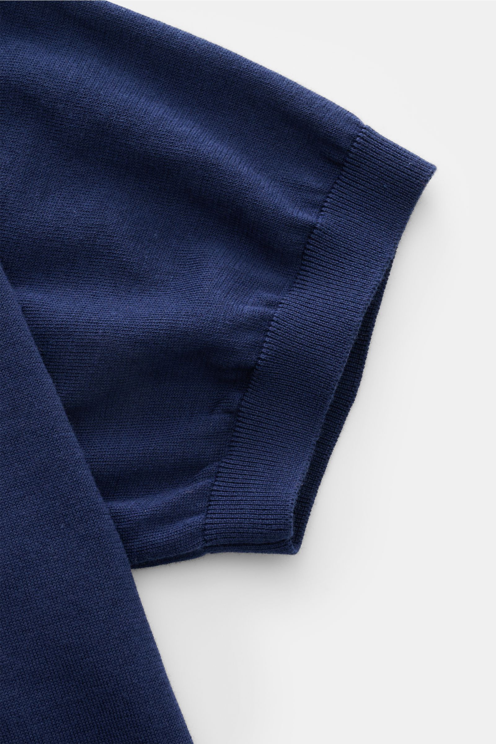 Nahaufnahme des Ärmels vom Drumohr Kurzarm-Strickpolo navy aus feinem, weichem Baumwoll-Feinstrick mit elastischem Rippbündchen.
