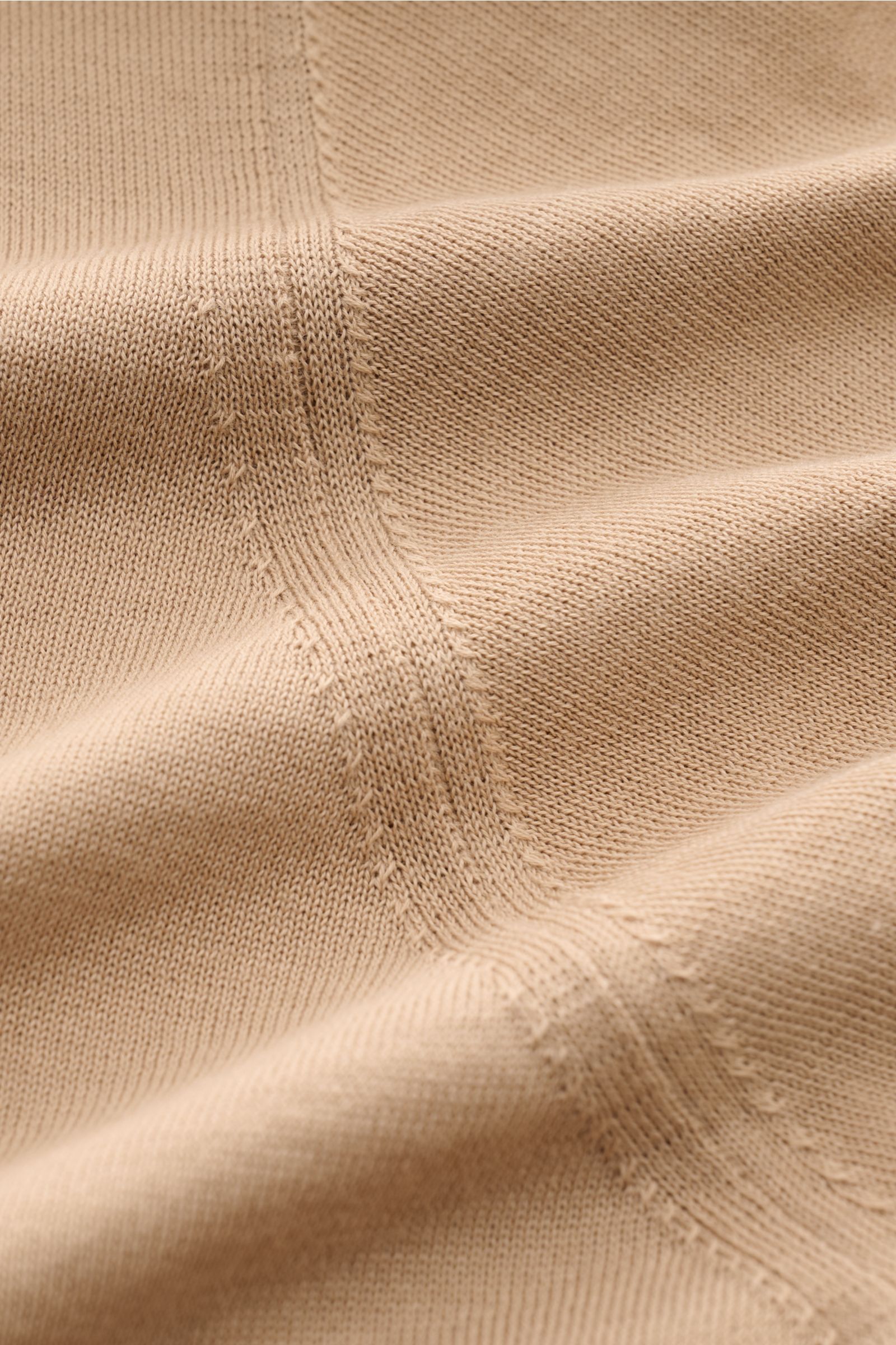 Nahaufnahme des feinen Strickbilds und der Naht des hellbraunen Drumohr Kurzarm-Strickpolo aus weicher Baumwolle.