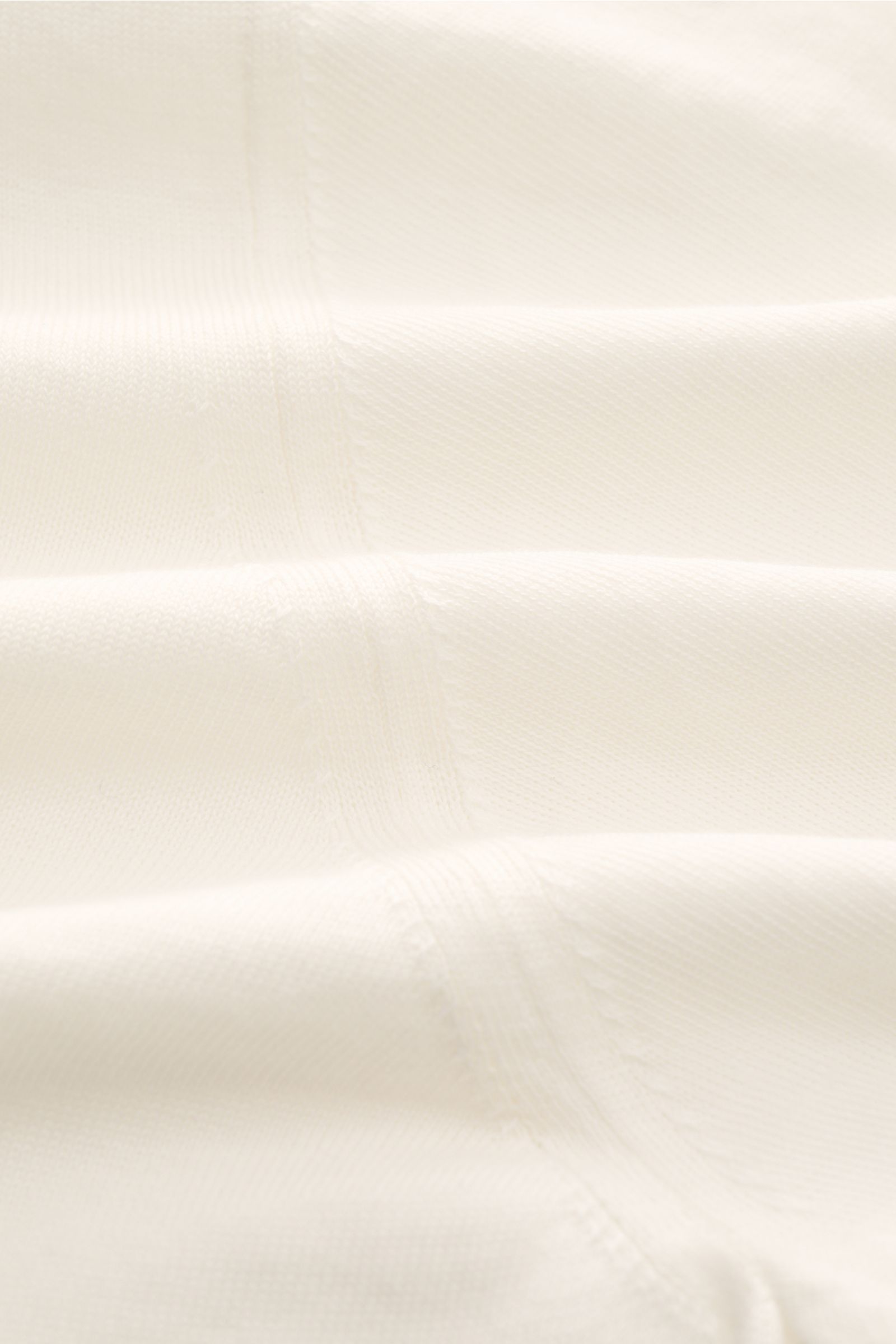 Nahaufnahme des feinen Strickbilds und der weichen Baumwolle des Drumohr Kurzarm-Strickpolo offwhite, Slim Fit, mit elastischen Rippbündchen.