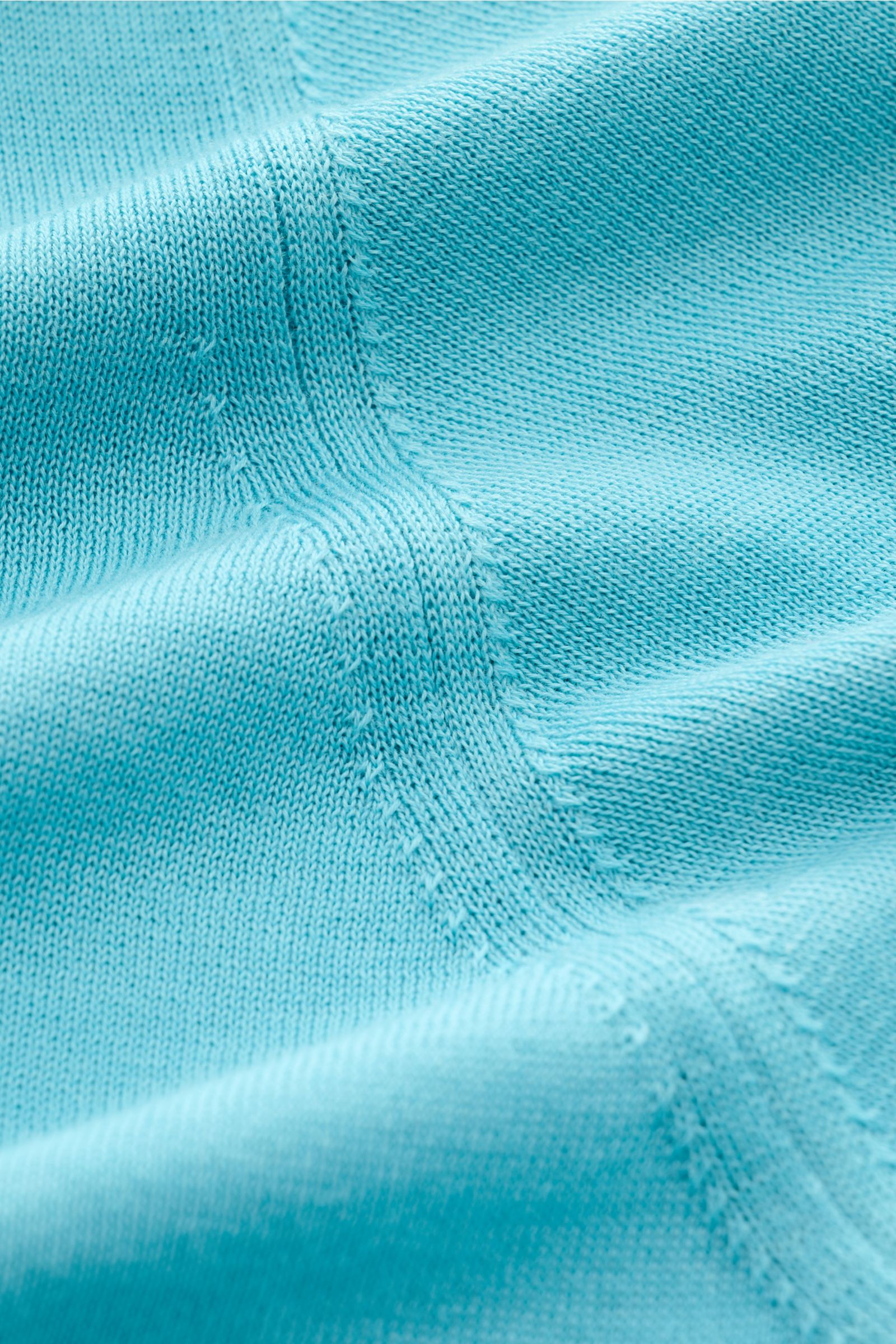 Nahaufnahme des feinen Strickbilds des Drumohr Kurzarm-Strickpolo azurblau aus weicher, atmungsaktiver Baumwolle, seitlich fotografiert.