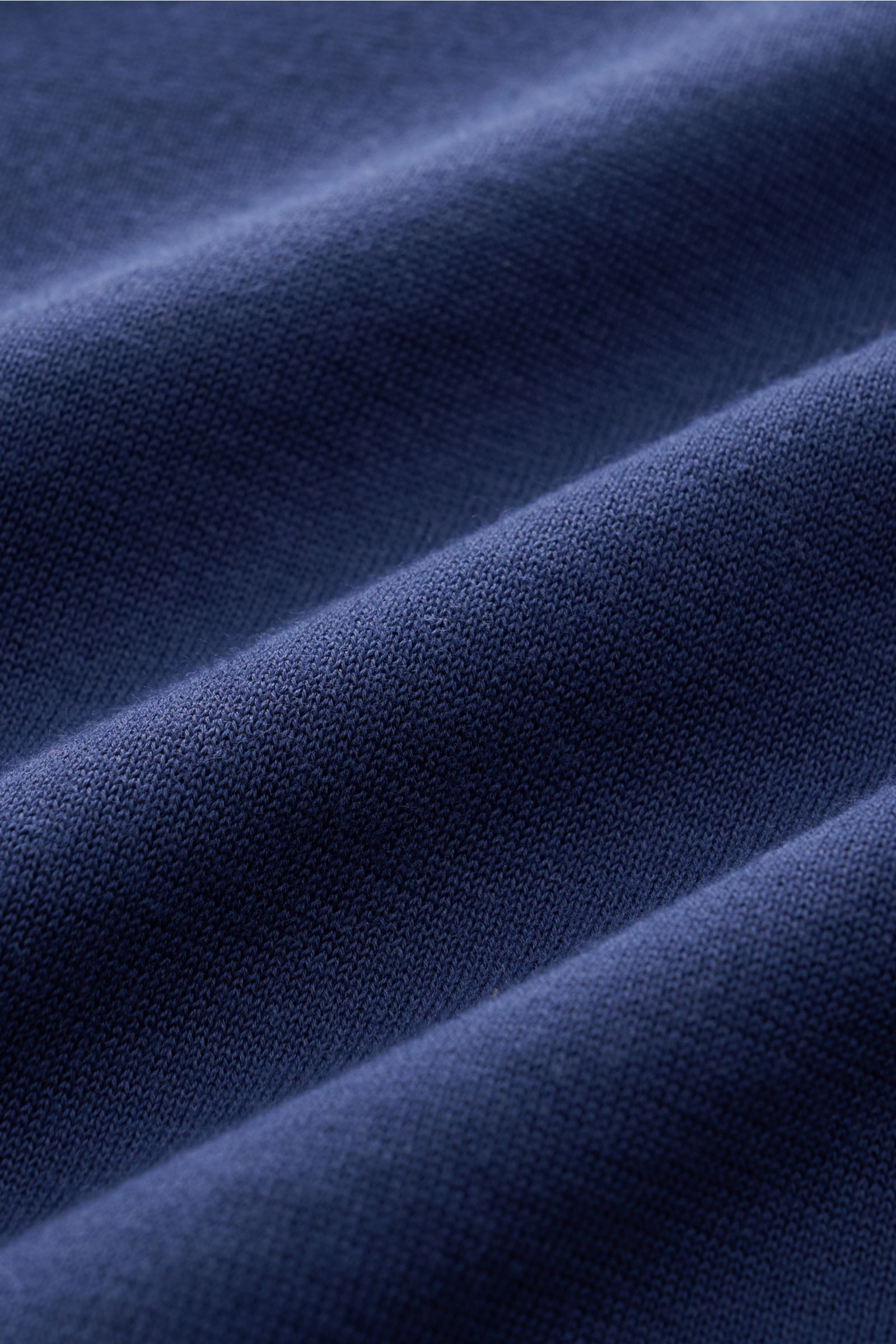 Drumohr Kurzarm-Strickpolo dunkelblau aus feinem Baumwoll-Feinstrick, weicher Griff, offene Kragenleiste, elastische Rippbündchen, Nahaufnahme Stoffstruktur.