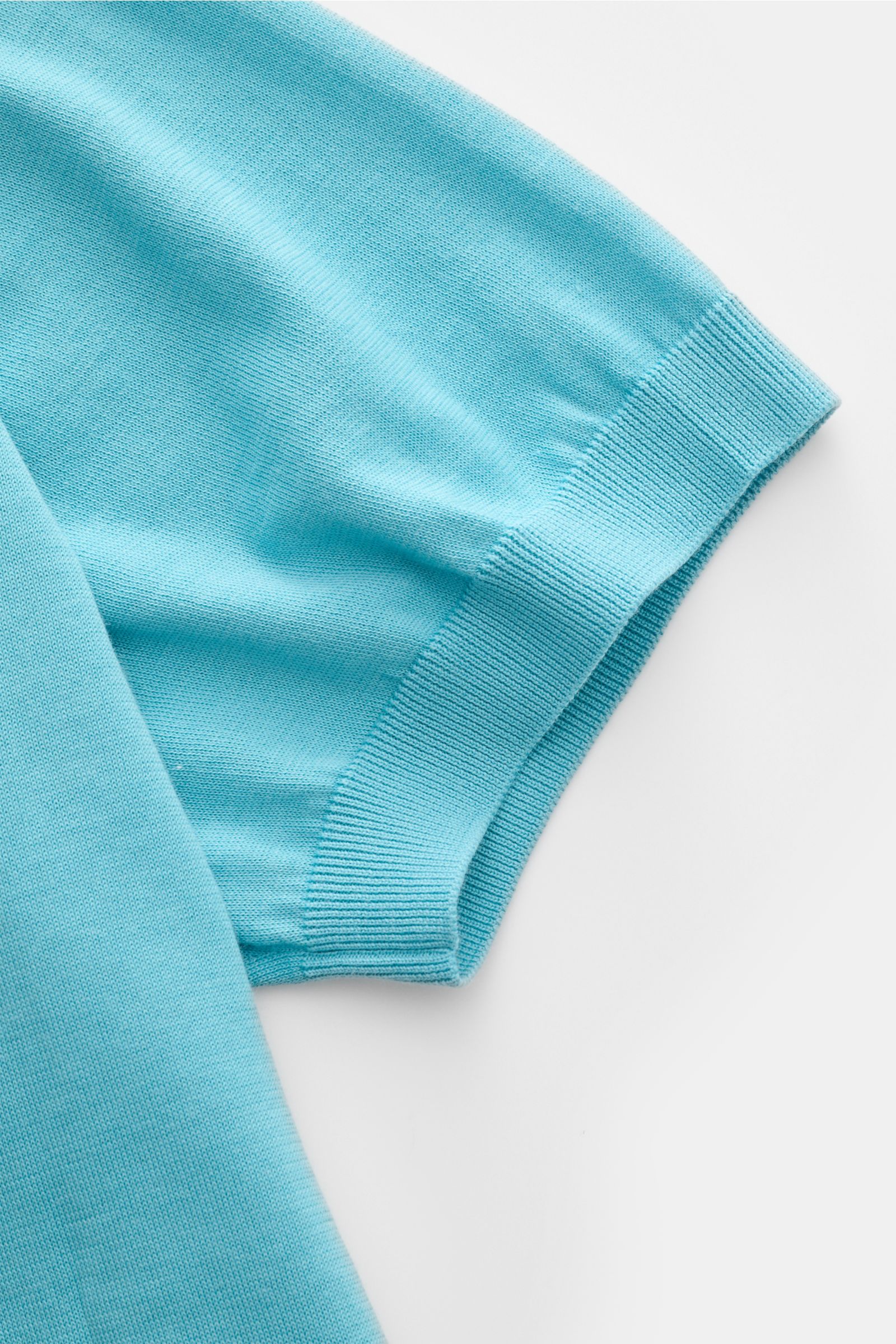 Close-up view of the sleeve of Drumohr Short sleeve knit polo blue, showing fine knit, elasticated ribbed band, and soft cotton fabric.

Description:  
A fine essential from label DRUMOHR: This Italian-made short sleeve knit polo is made of comfortably
