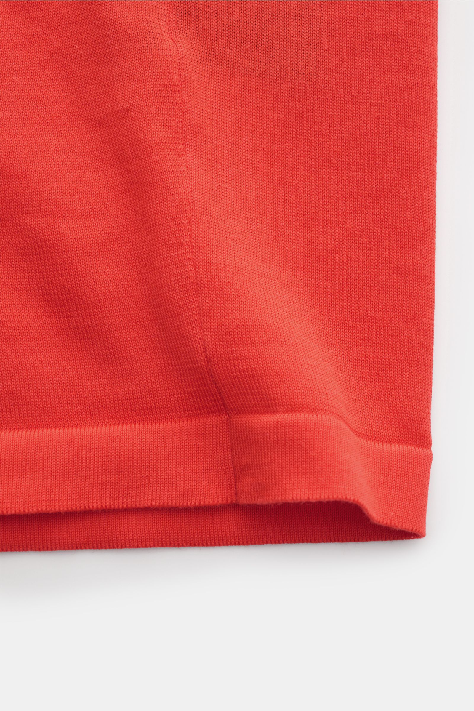 Close-up of the straight hem and knit texture of the Drumohr Short sleeve knit shirt light red, photographed from a side angle. Stylish casual look: This knit shirt by DRUMOHR is a versatile piece for your spring wardrobe. Pure cotton, very soft feel, reg