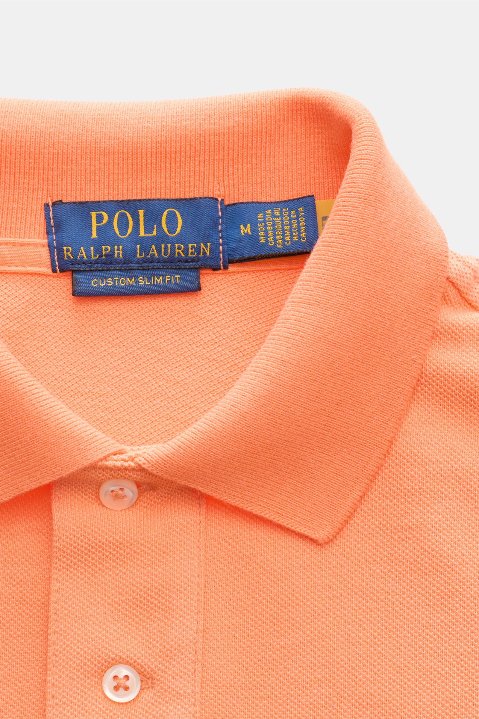 Close-up front view of Polo Ralph Lauren Polo shirt orange with classic collar and two-button placket, made from pure cotton piqué. The classic among polo shirts since 1972: The iconic pure cotton piqué model with the famous polo rider stitching on the