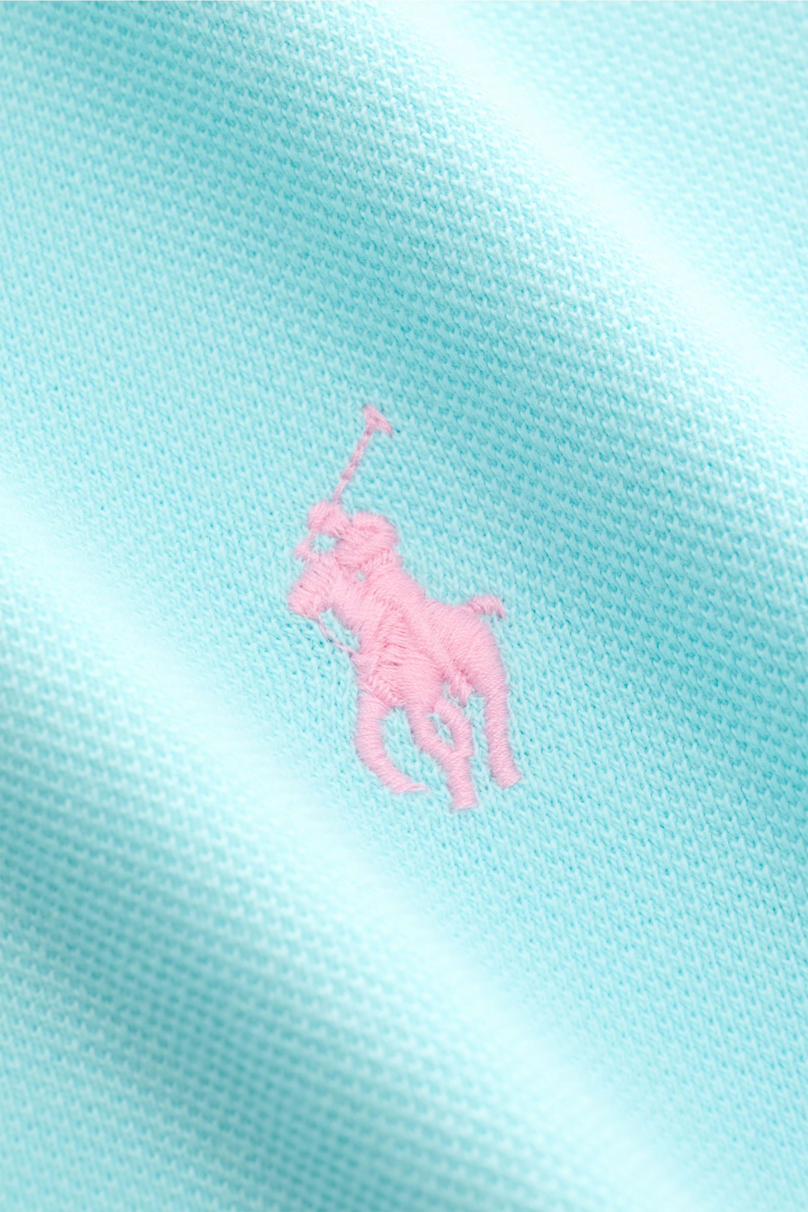 Nahaufnahme des Polo Ralph Lauren Poloshirt hellblau mit feinem Piqué aus reiner Baumwolle und rosa Poloreiter-Stitching.