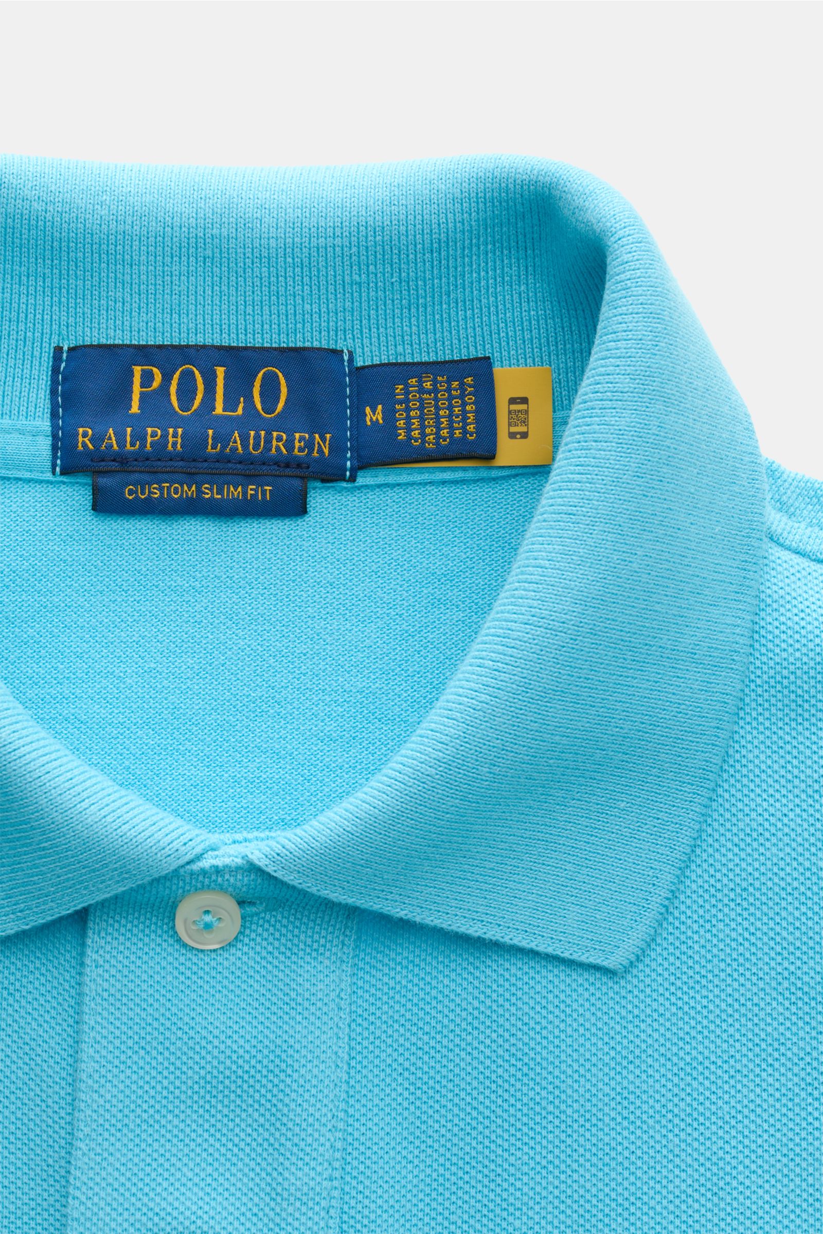 Polo Ralph Lauren Poloshirt azurblau in Slim Fit aus reiner Baumwolle mit Piqué-Struktur, Polokragen, Zwei-Knopf-Leiste, elastischen Ärmelbündchen, fotografiert von oben.