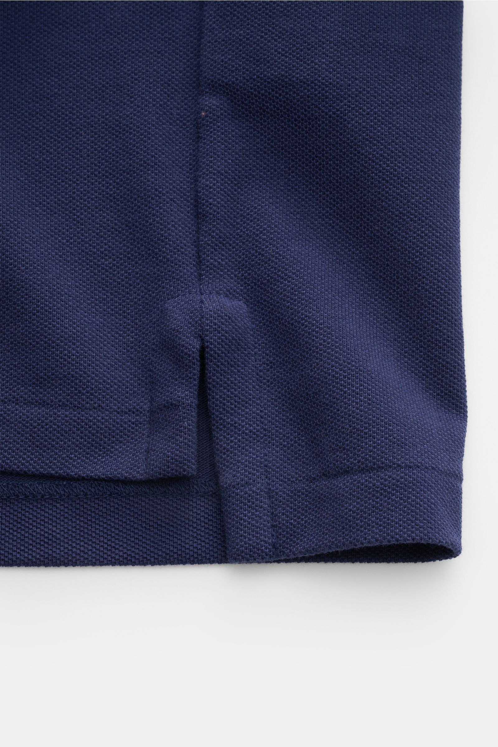Close-up of the hem with side vents on the Polo Ralph Lauren Polo shirt navy, shown from a flat lay perspective.

The classic among polo shirts since 1972: The iconic pure cotton piqué model with the famous polo rider stitching on the chest will always
