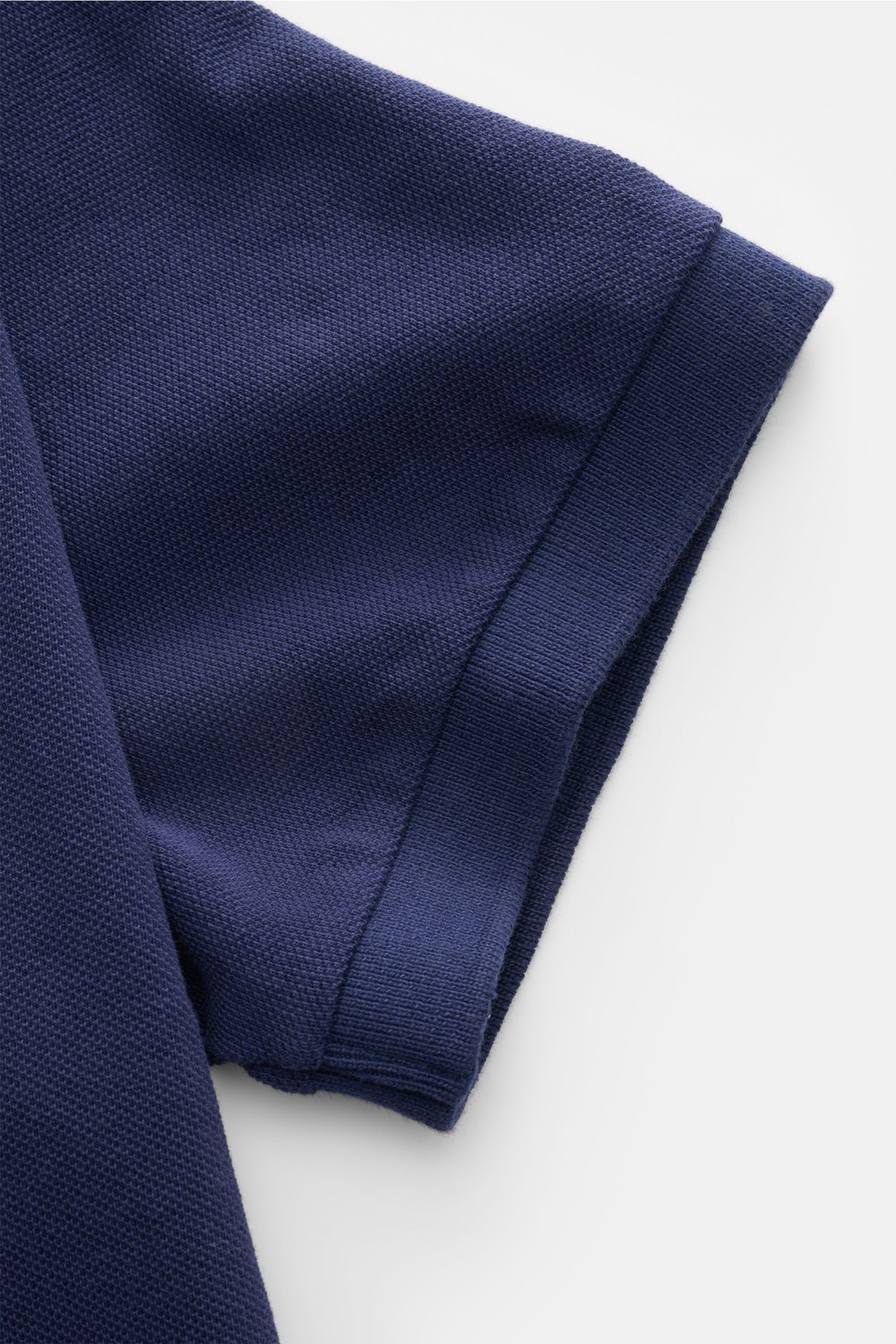Close-up top view of Polo Ralph Lauren Polo shirt navy sleeve showing fine piqué texture, elasticated cuff, and pure cotton fabric.

Description: The classic among polo shirts since 1972: The iconic pure cotton piqué model with the famous polo rider stitc