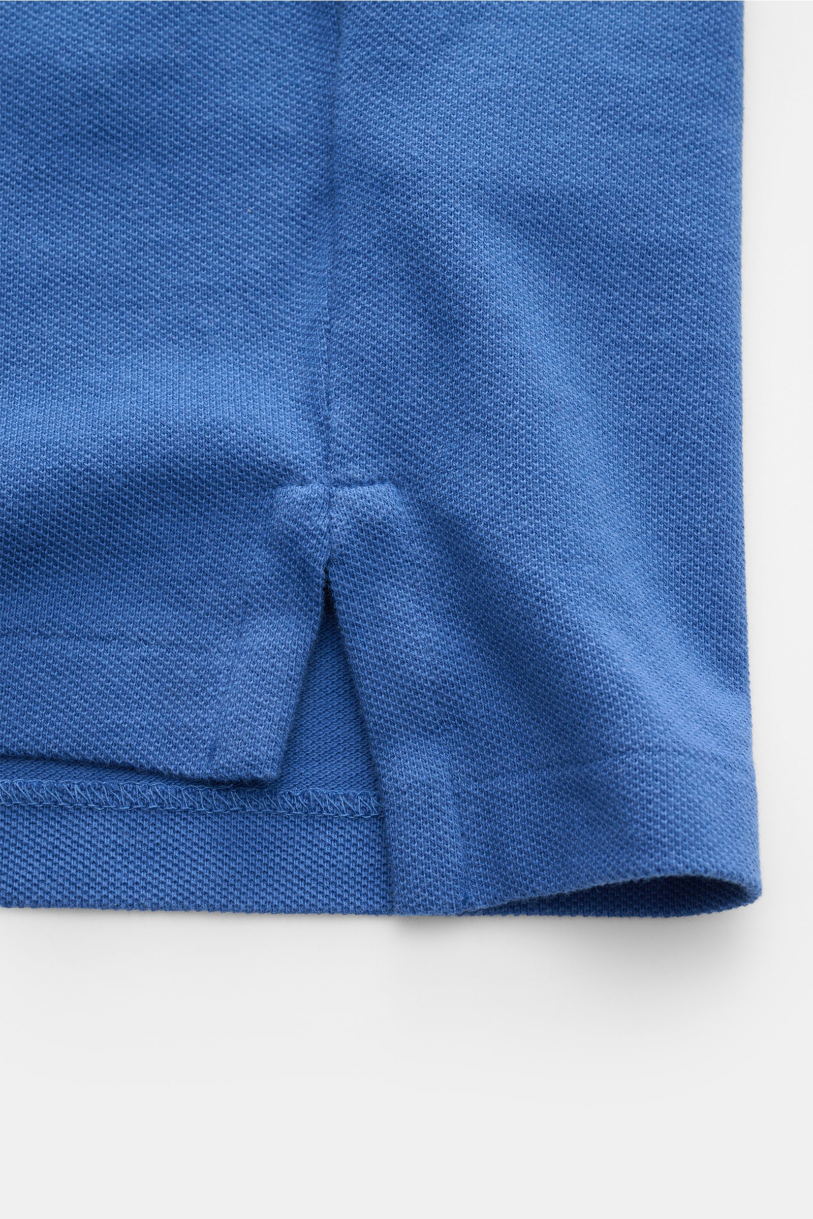 Close-up of the hem side vent of the Polo Ralph Lauren Polo shirt dark blue, showing fine piqué cotton texture from a top-down perspective. The classic among polo shirts since 1972: The iconic pure cotton piqué model with the famous polo rider stitching o