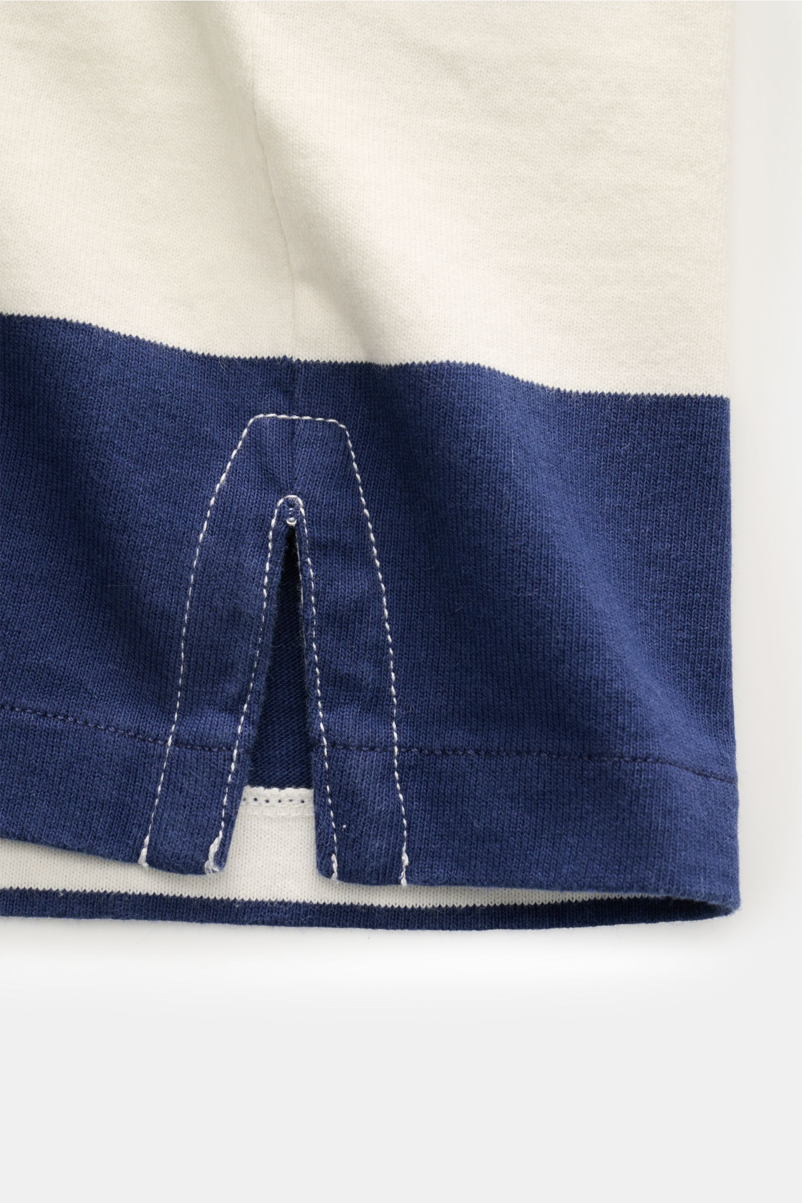 Close-up of hem detail of Polo Ralph Lauren Polo shirt navy/off-white striped, showing side vents and stitching from a front angle.

Description: The absolute classic among polo shirts since 1972: The iconic pure cotton polo shirt with the legendary po