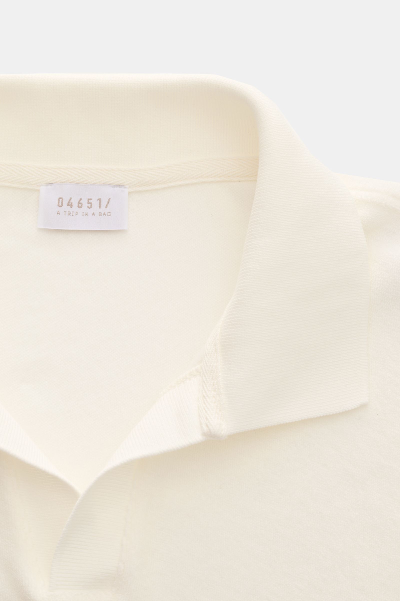 Nahaufnahme des offwhite 04651/ A trip in a bag Frottee-Poloshirt 'Terry Johnny' mit typischem Polokragen und offener Kragenleiste aus Baumwoll-Frottee.