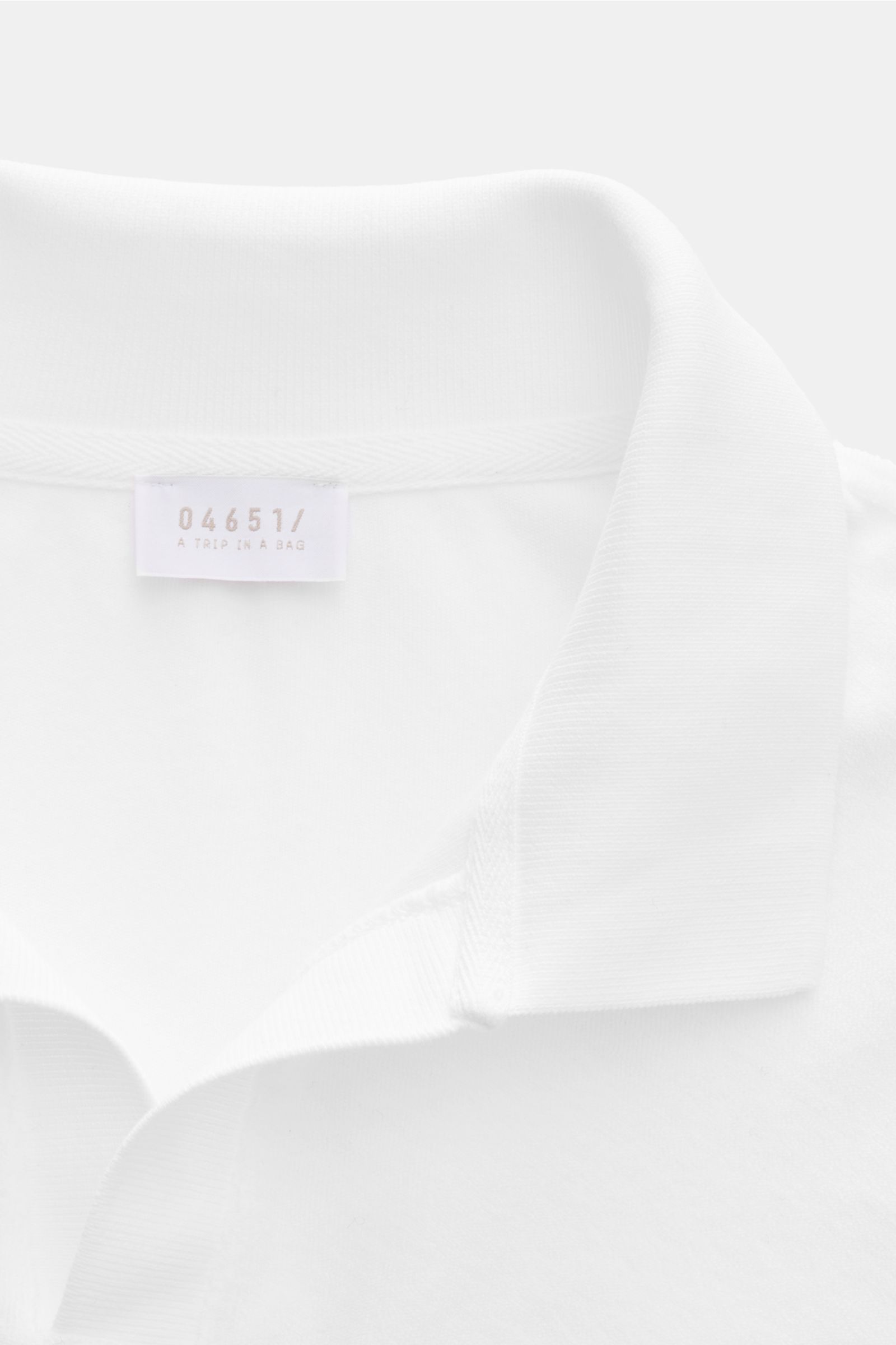 Close-up front view of the white 04651/ A trip in a bag Terry polo shirt 'Terry Johnny' with signature collar and label.