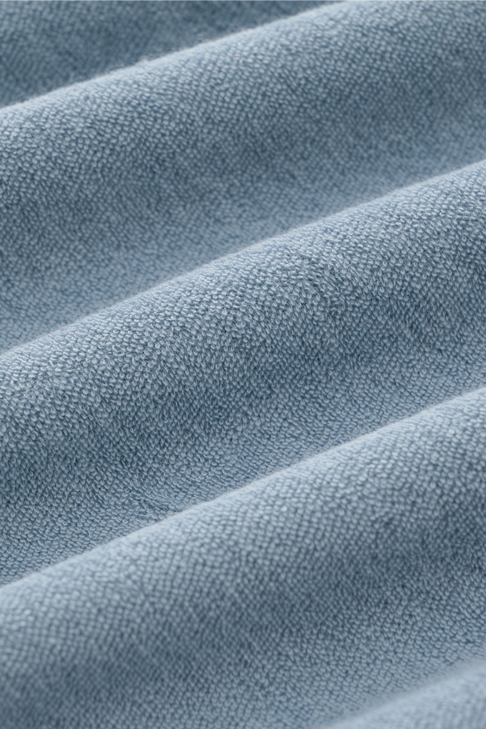 Close-up front view of the 04651/ A trip in a bag Terry polo shirt 'Terry Johnny' smoky blue, showing soft cotton terry fabric texture.

Holiday feel you can wear: This short sleeve polo shirt in comfortable cotton terry by 04651/ A TRIP IN A BAG is a 