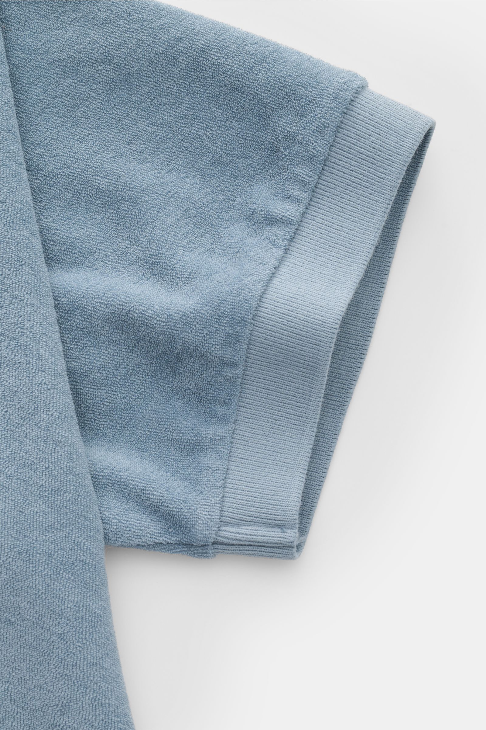 Close-up, top-down view of the short sleeve cuff of the 04651/ A trip in a bag Terry polo shirt 'Terry Johnny' smoky blue in soft cotton terry.

Holiday feel you can wear: This short sleeve polo shirt in comfortable cotton terry by 04651/ A TRIP IN A B
