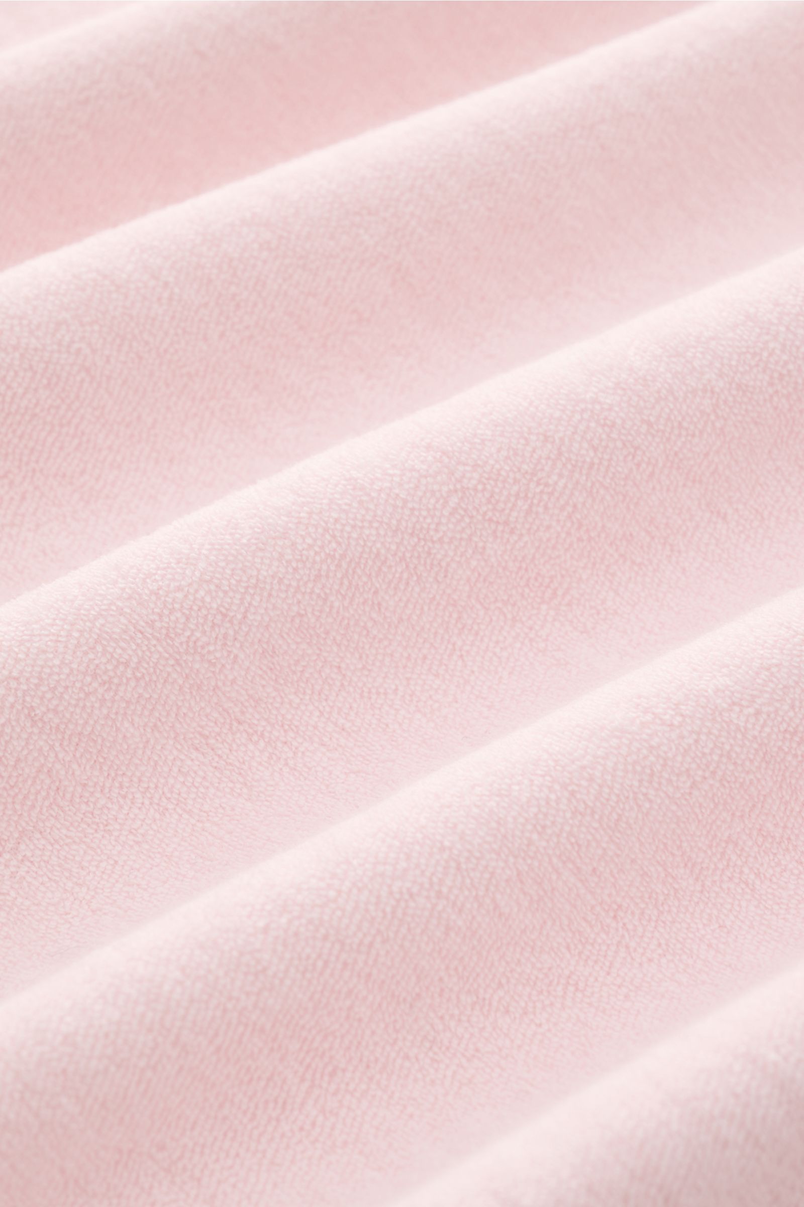 Close-up front view of soft pink terry cotton fabric texture from the 04651/ A trip in a bag Terry polo shirt 'Terry Johnny' rose.

Description: Holiday feel you can wear: This short sleeve polo shirt in comfortable cotton terry by 04651/ A TRIP IN A B