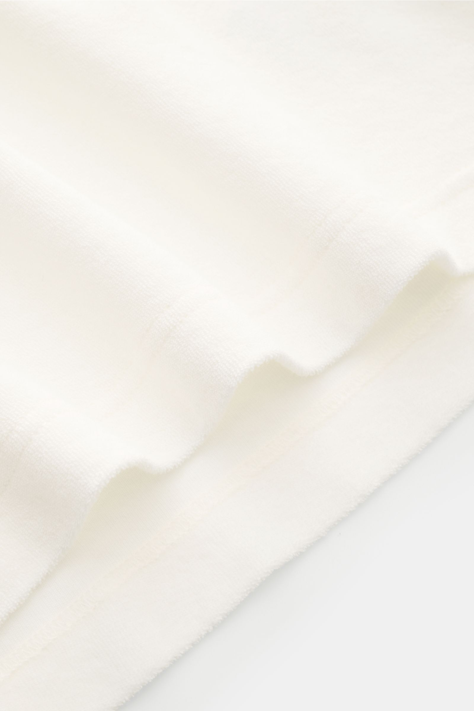 04651/ A trip in a bag Frottee-Poloshirt 'Terry Polo' offwhite aus reiner Baumwolle, Regular Fit, Polokragen, Knopfleiste, Seitennaht-Label, Saumschlitze, Detailaufnahme der Stoffstruktur.