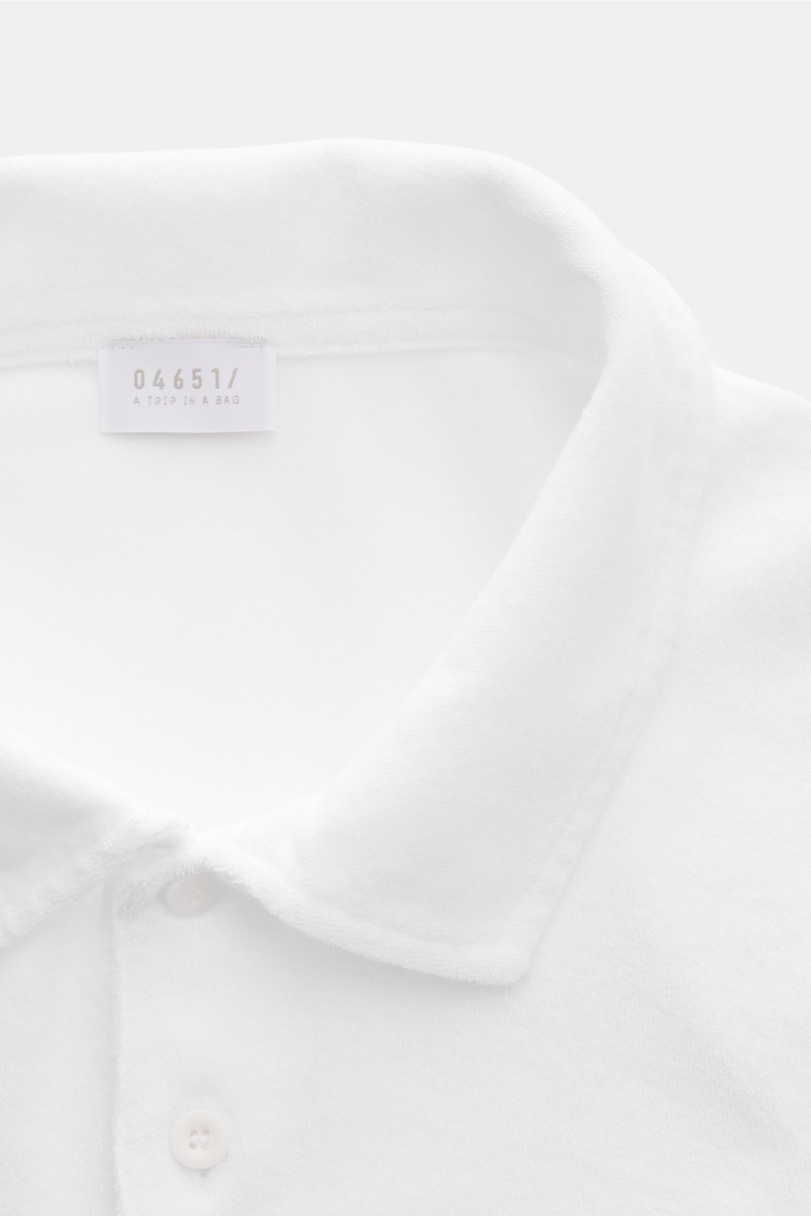 04651/ A trip in a bag Frottee-Poloshirt 'Terry Polo' weiß, Detailaufnahme von oben, weicher Baumwollstoff, Regular Fit, Polokragen, Knopfleiste.