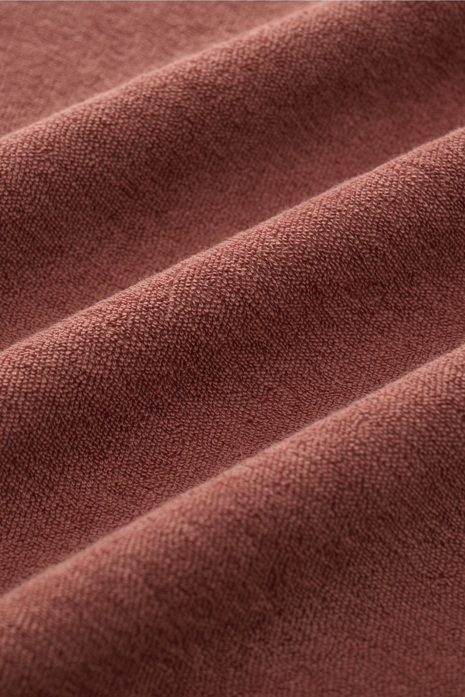 Nahaufnahme des weichen Frottee-Stoffs in rostbraun, Detailtextur des 04651/ A trip in a bag Frottee-Poloshirts 'Terry Polo' aus reiner Baumwolle.