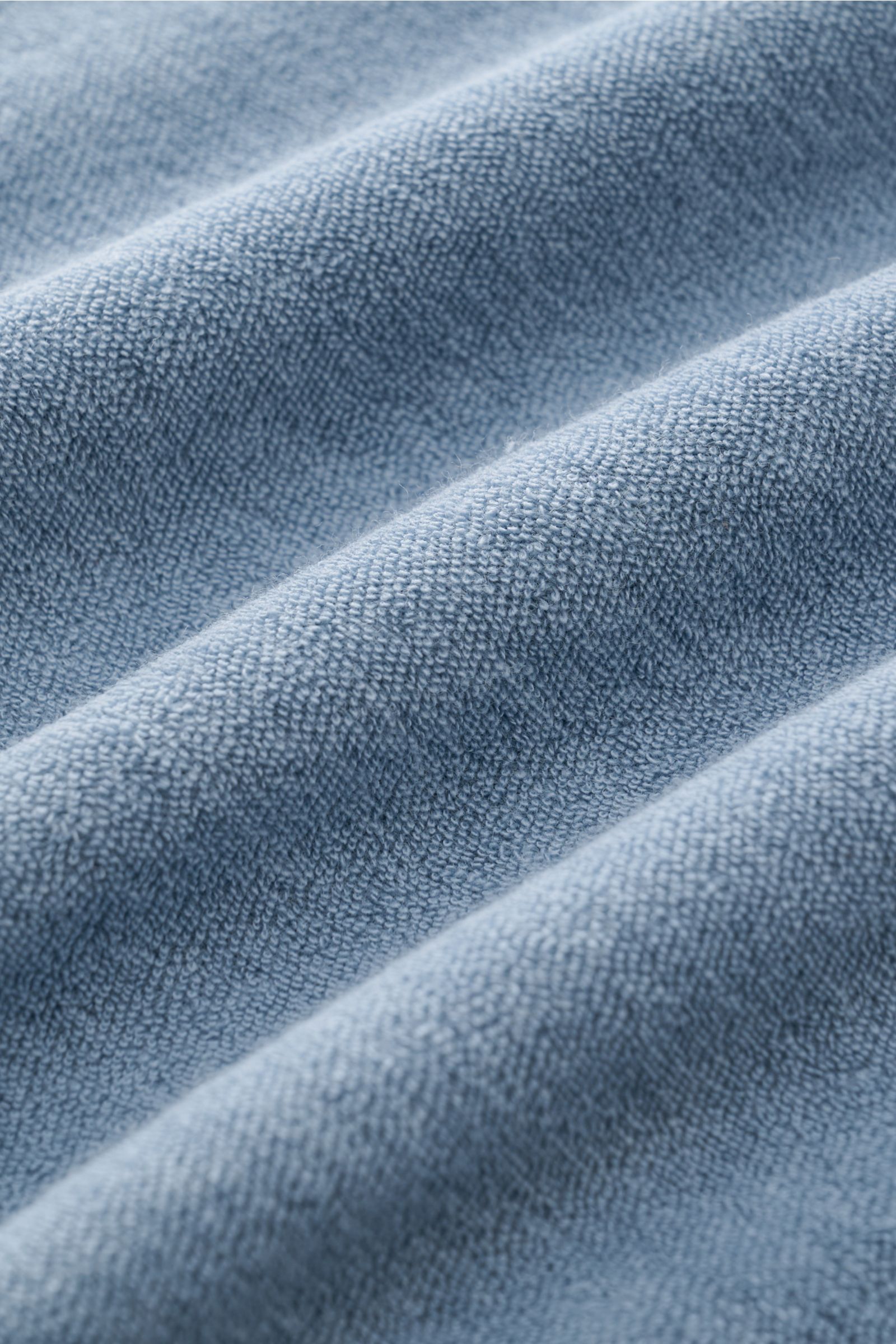 Nahaufnahme von rauchblauem 04651/ A trip in a bag Frottee-Poloshirt 'Terry Polo' Stoff aus reiner Baumwolle mit weichem Griff.