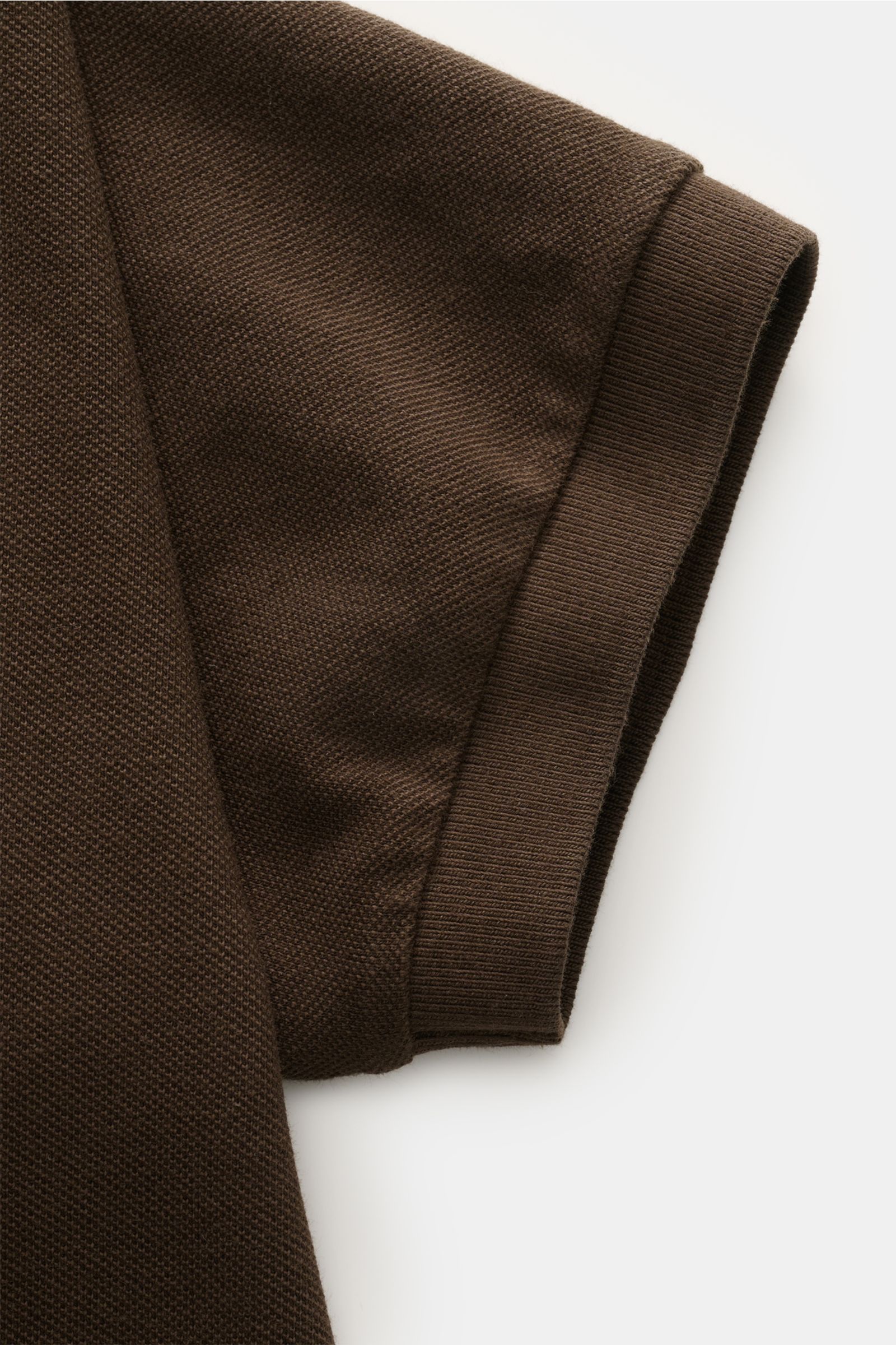 Close-up view of the sleeve hem of 04651/ A trip in a bag Polo shirt 'Johnny' dark brown in pure piqué cotton with ribbed cuff.

For relaxed casual looks: 04651/ A TRIP IN A BAG brings a relaxed summer vibe to your wardrobe with this pure cotton polo s