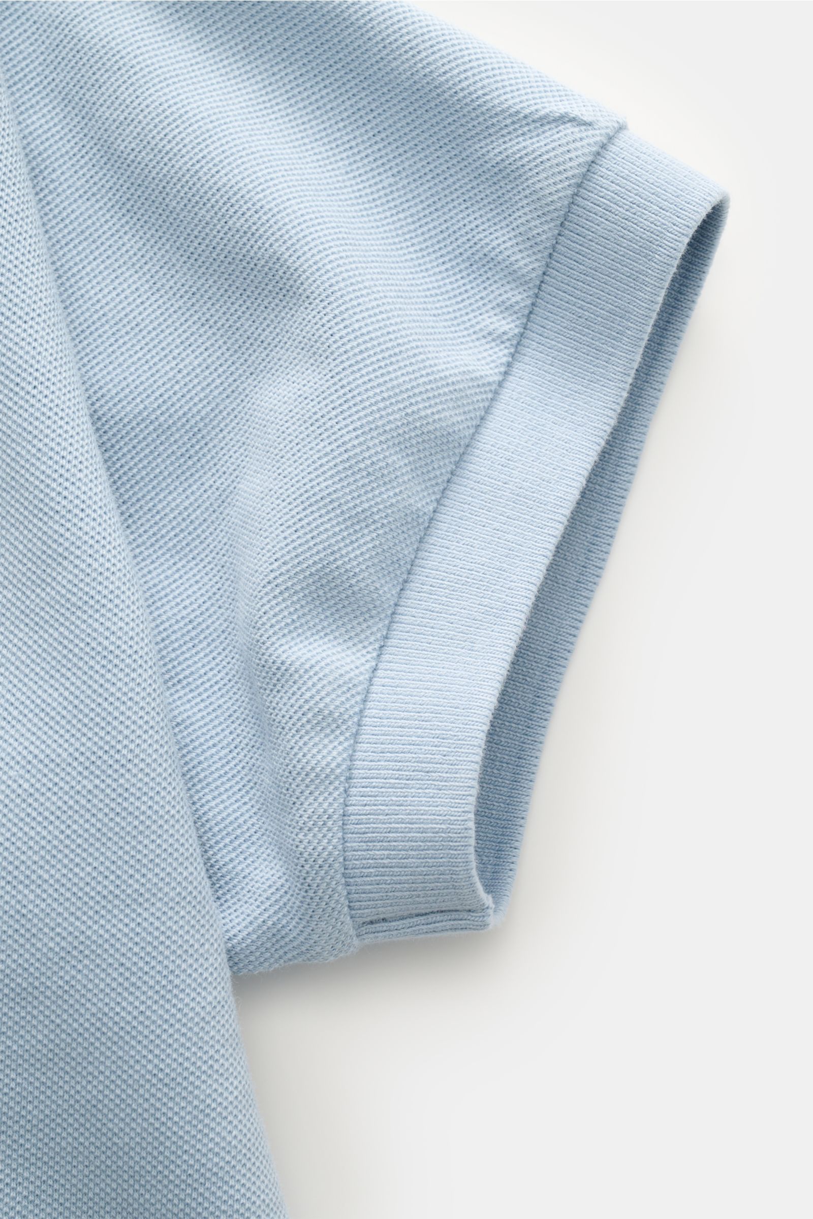 Close-up side view of the sleeve of the 04651/ A trip in a bag Polo shirt 'Johnny' smoky blue made of pure piqué cotton with comfortable cuffs.

For relaxed casual looks: 04651/ A TRIP IN A BAG brings a relaxed summer vibe to your wardrobe with this pu