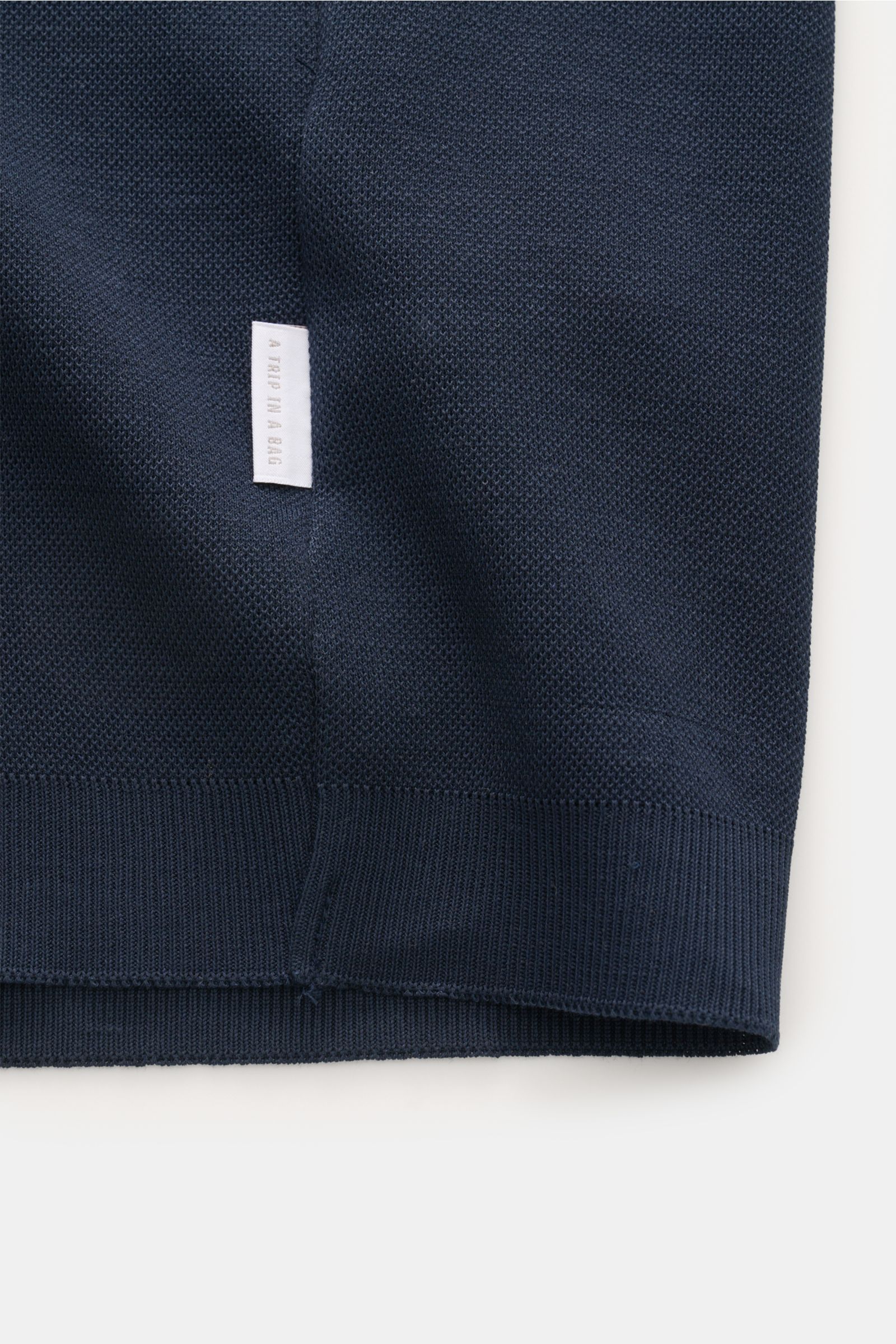 04651/ A trip in a bag Poloshirt 'TP' navy in Nahaufnahme von Saum mit Weblabel, Piqué aus Baumwolle, Regular Fit, weicher Griff, Rippbündchen.