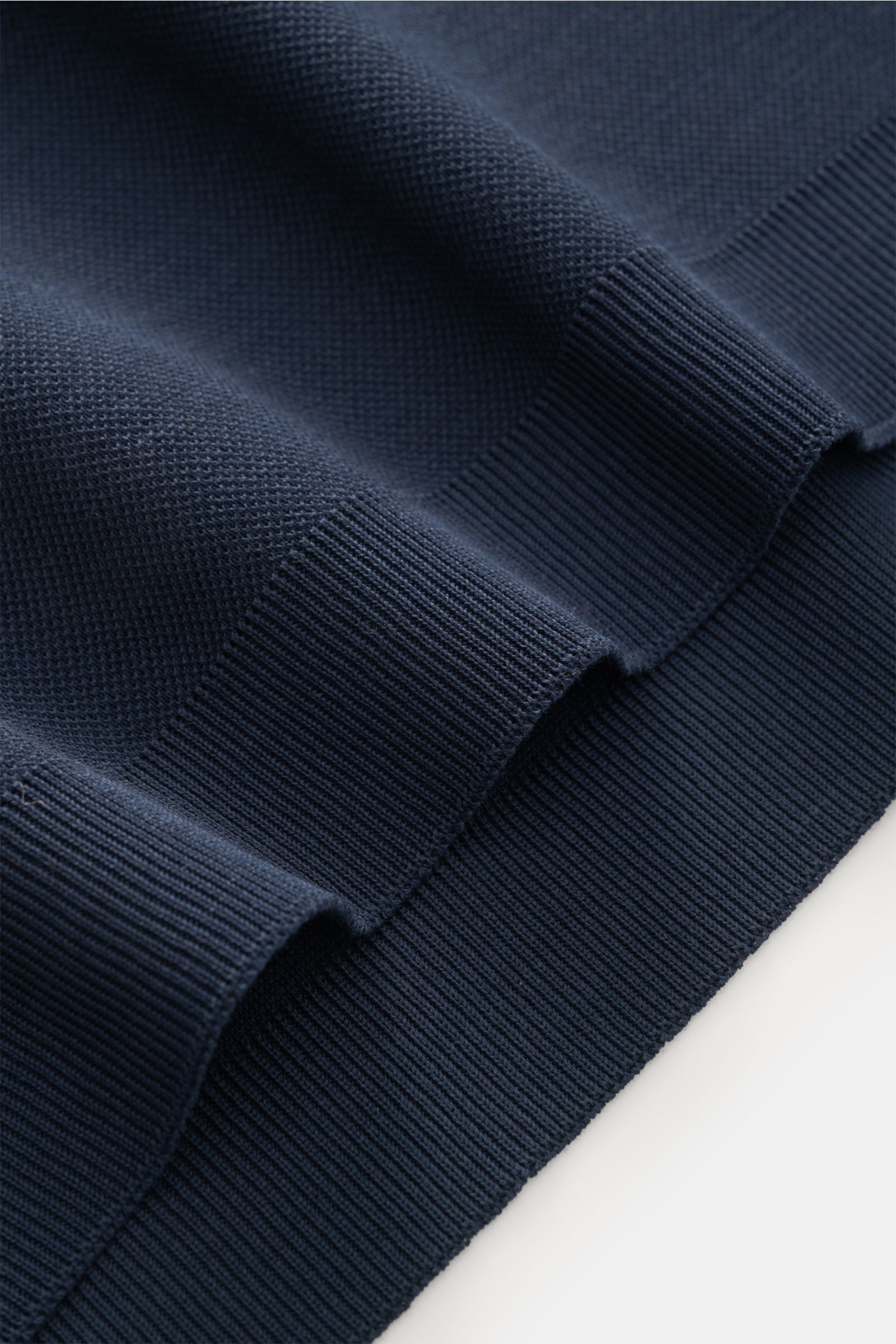 Nahaufnahme aus seitlicher Perspektive des navyfarbenen 04651/ A trip in a bag Poloshirt 'TP' navy mit Piqué-Baumwolle, weichem Griff, Rippbündchen und glatter Knopfleiste.