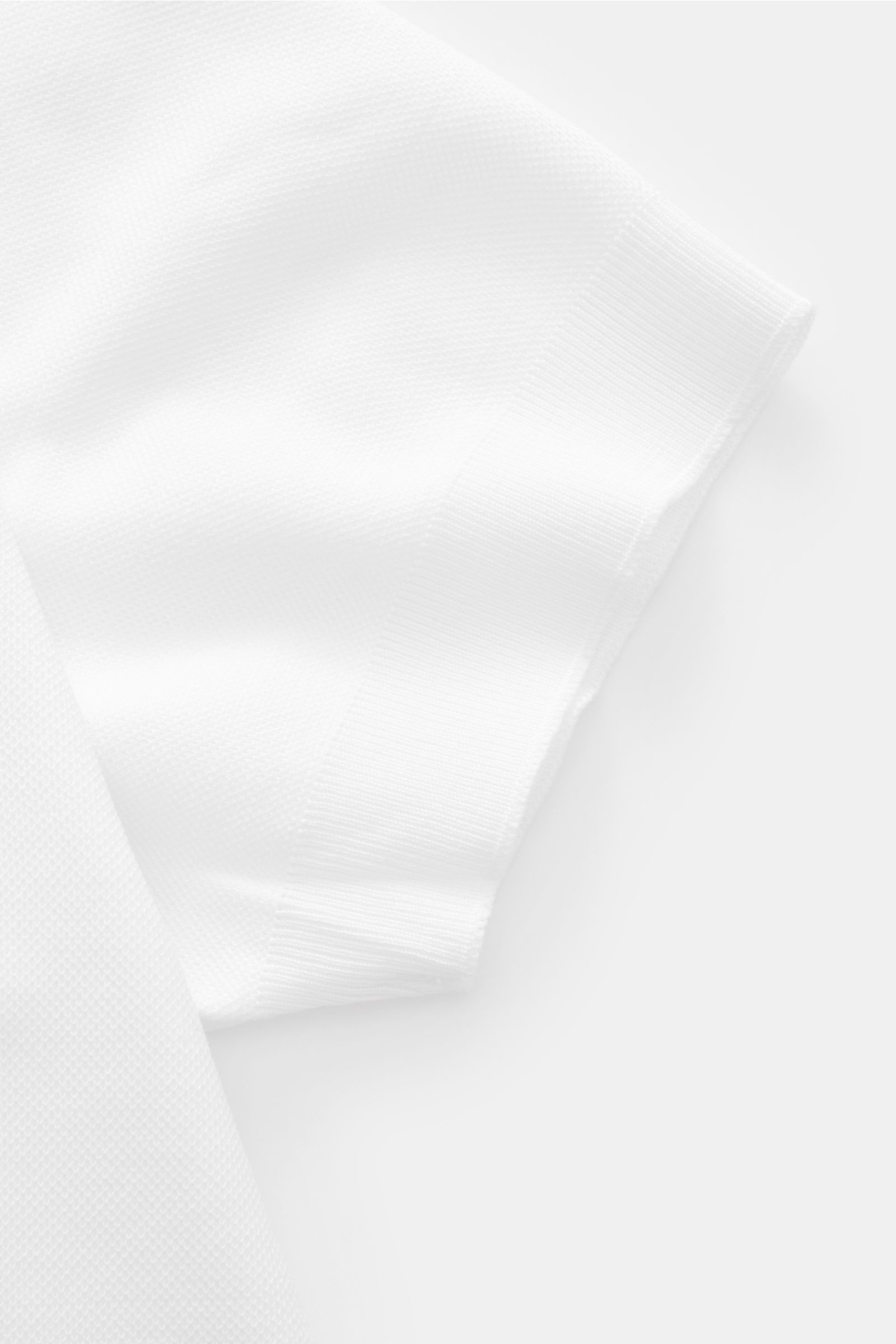 Close-up side view of the sleeve of the 04651/ A trip in a bag Poloshirt 'TP' weiß, made of pure cotton piqué with soft touch, regular fit, classic polo collar, smooth button placket, small side seam web label, and comfortable ribbed cuffs. Ob im Urlau
