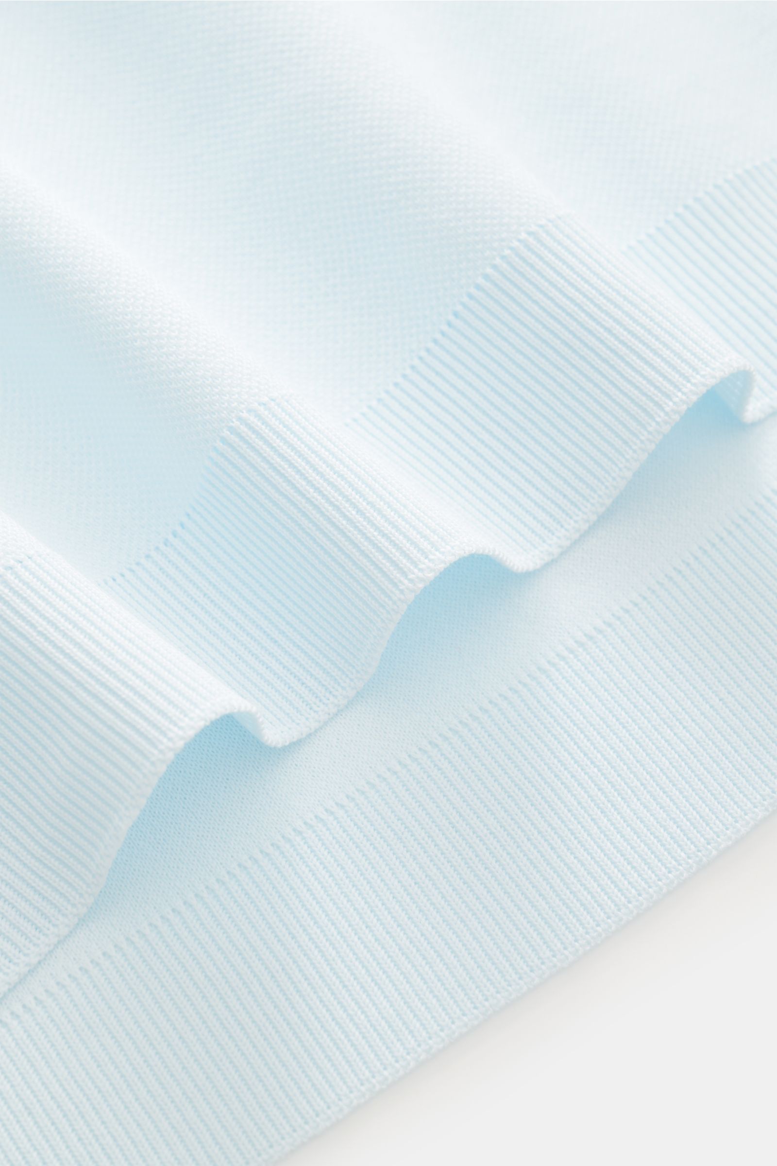 A close-up front view of the ribbed cuffs and soft piqué fabric of the 04651/ A trip in a bag Poloshirt 'TP' pastellblau. Ob im Urlaub oder Office: 04651/ A TRIP IN A BAG bringt mit dem Poloshirt aus reiner Baumwolle lässiges Sommergefühl in Ihre Garde