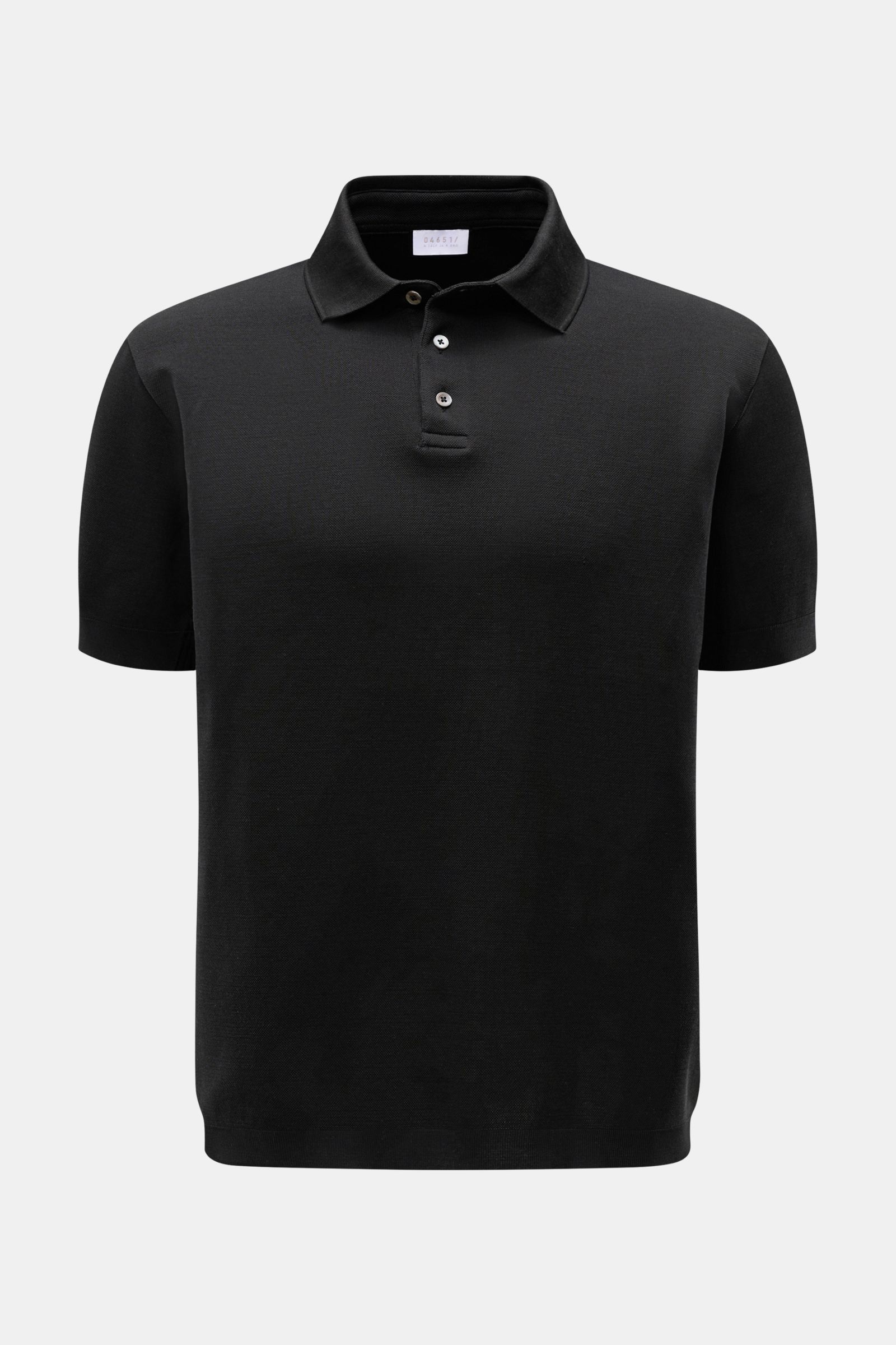 Front view of the 04651/ A trip in a bag Poloshirt 'TP' schwarz in black, showcasing a classic polo collar, smooth button placket, and short sleeves. Ob im Urlaub oder Office: 04651/ A TRIP IN A BAG bringt mit dem Poloshirt aus reiner Baumwolle lässige