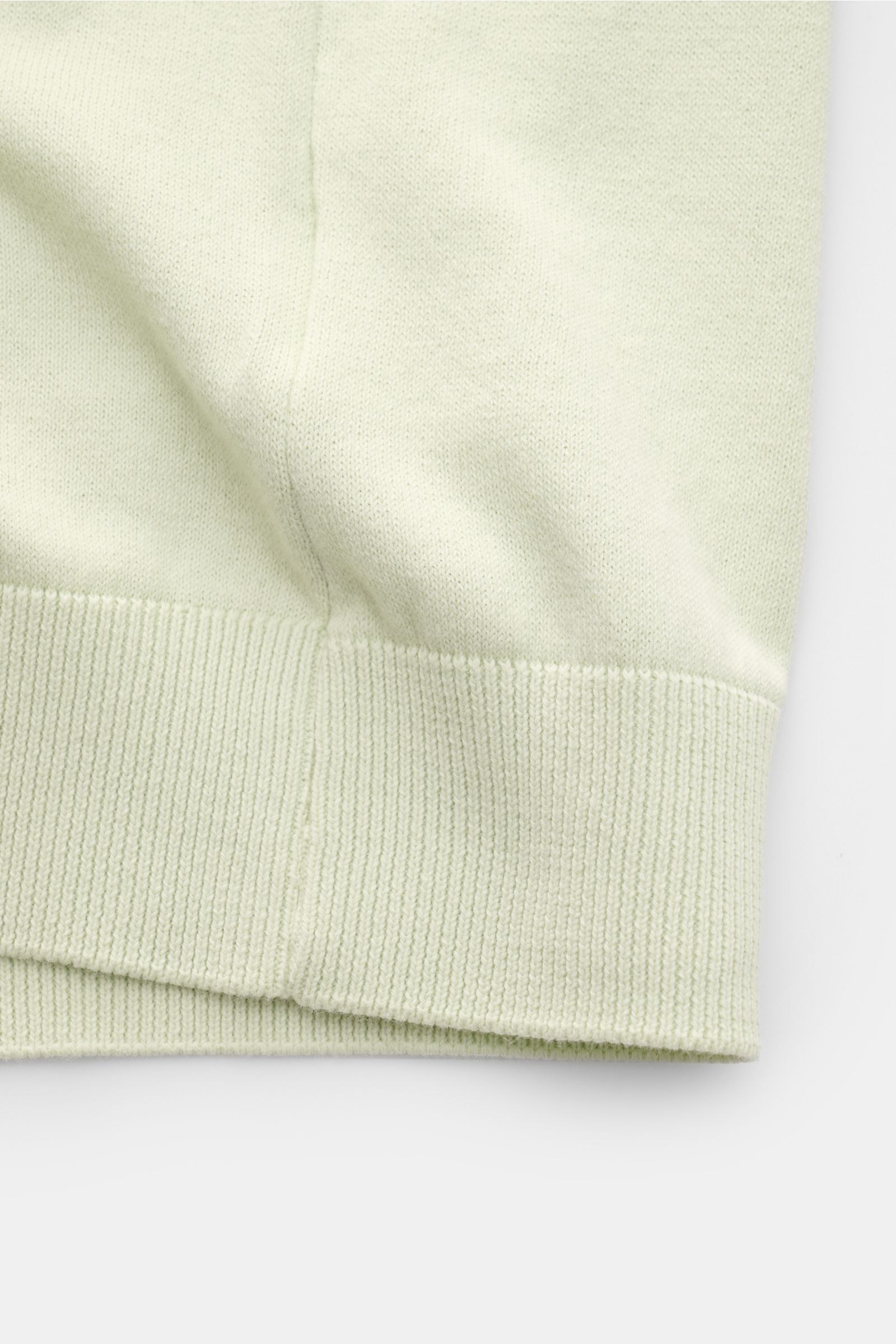 04651/ A trip in a bag Kurzarm-Strickpolo 'Pima Cotton' pastellgrün, Detailaufnahme des feinen Feinstricks mit weichem Griff und flexiblem Rippbündchen, Perspektive von unten auf den Saum.