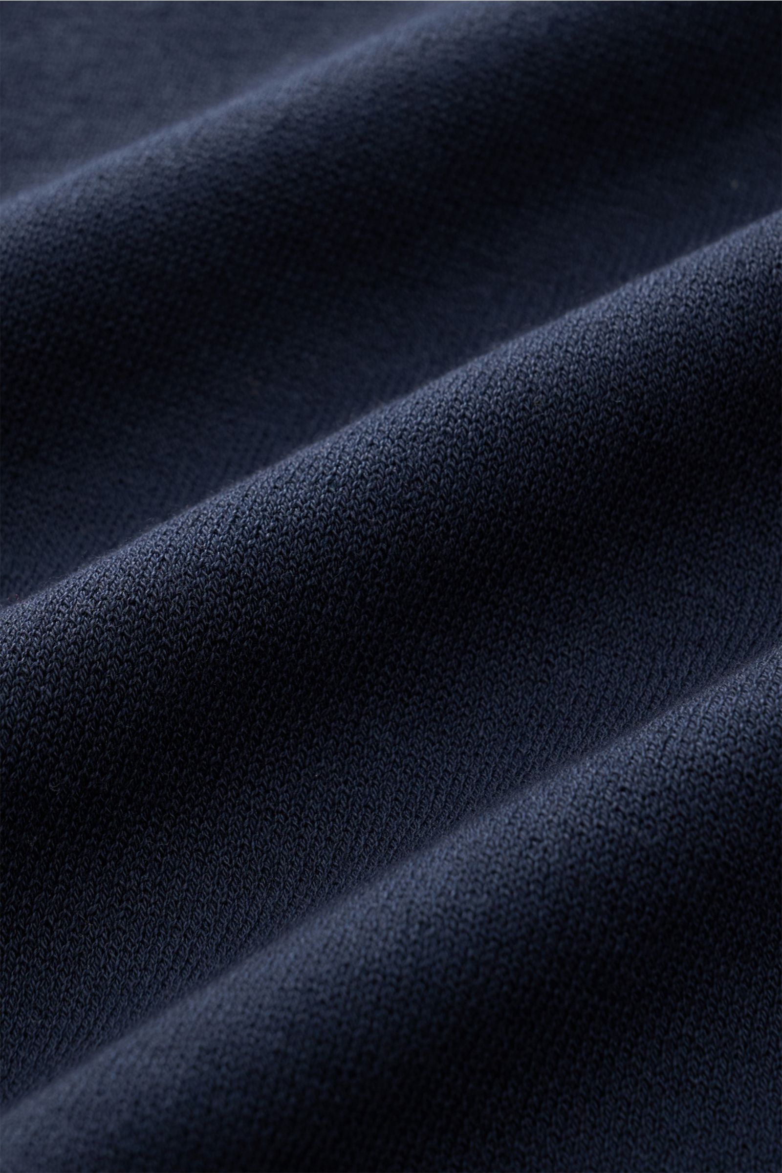 Nahaufnahme des feinen Strickbildes des navyfarbenen 04651/ A trip in a bag Kurzarm-Strickpolo 'Johnny' aus reiner Baumwolle mit weichem Griff.