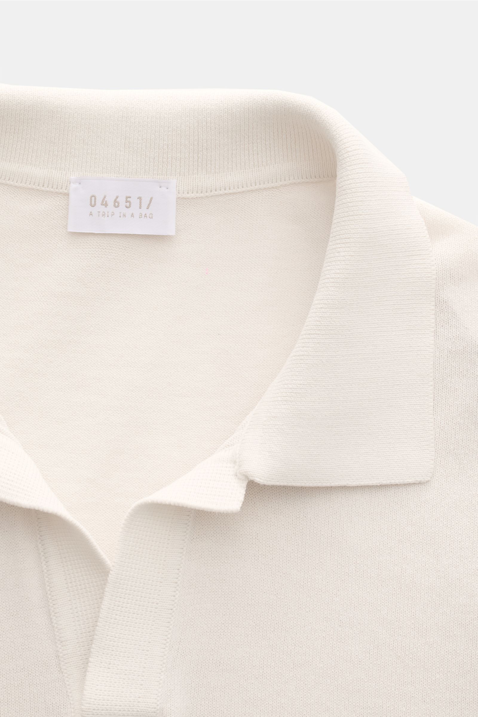04651/ A trip in a bag Kurzarm-Strickpolo 'Johnny' creme in Nahaufnahme von oben, feines Strickbild, Polokragen, Rippbündchen, Baumwolle, Regular Fit.