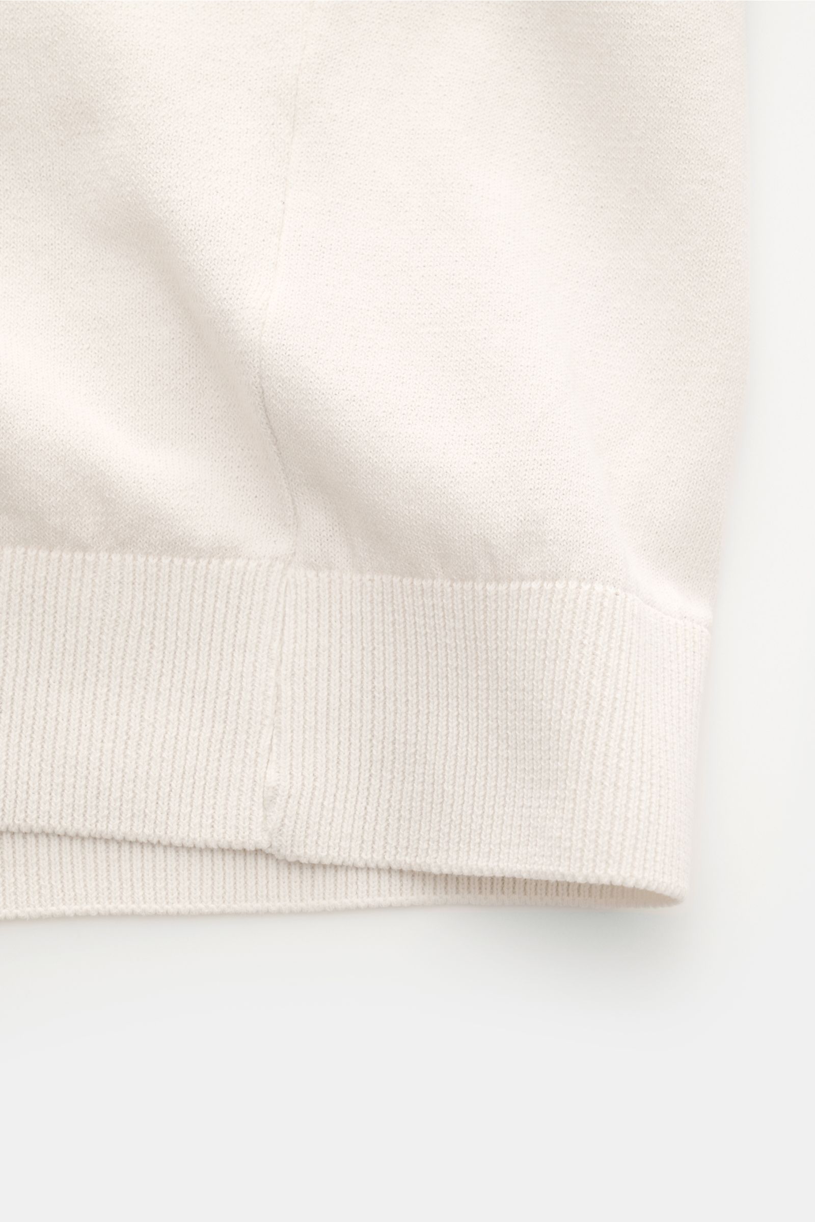 04651/ A trip in a bag Kurzarm-Strickpolo 'Johnny' creme, Detailaufnahme des unteren Saums, reine Baumwolle, weicher Griff, feines Strickbild, Regular Fit, Polokragen, Rippbündchen.