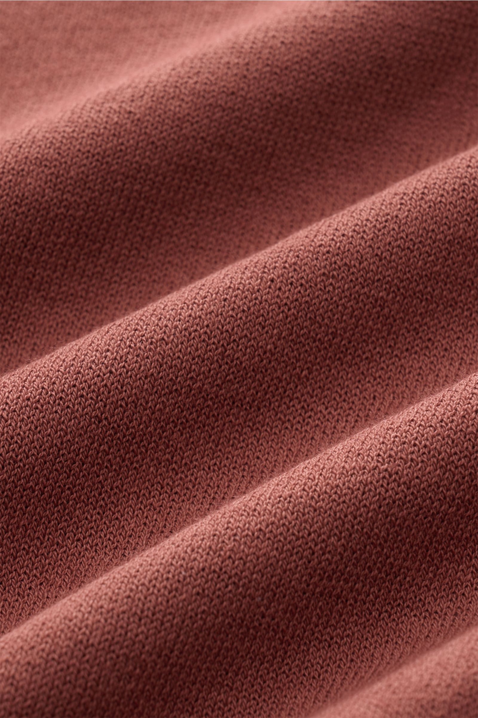 Nahaufnahme des weichen, rostbraunen Strickstoffs des 04651/ A trip in a bag Kurzarm-Strickpolo 'Johnny' mit feinem Strickbild, aufgenommen aus leichter Schräge.