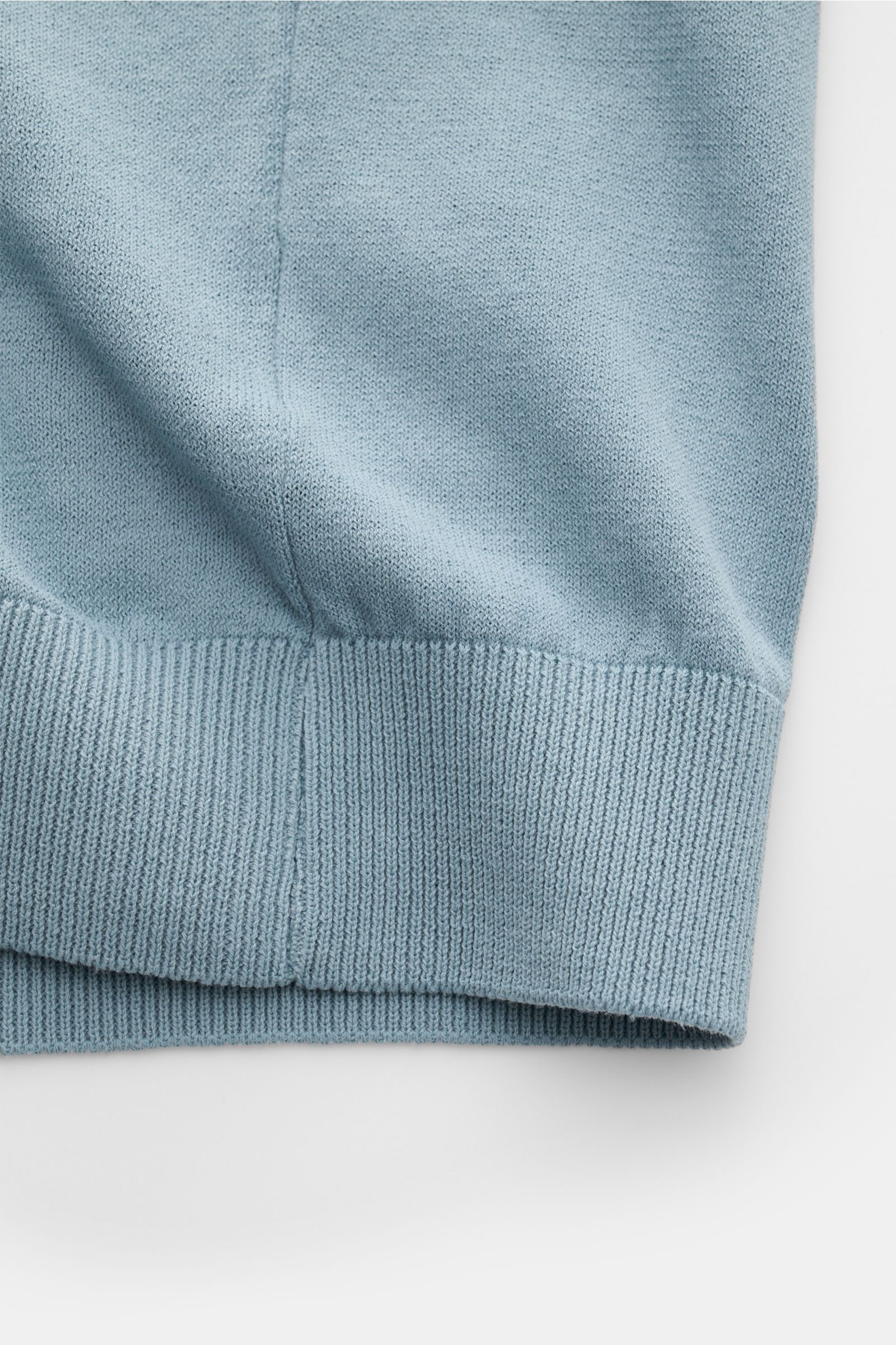 Nahaufnahme des Saums des 04651/ A trip in a bag Kurzarm-Strickpolo 'Johnny' rauchblau, reine Baumwolle, feines Strickbild, Regular Fit, klassischer Polokragen, komfortable Rippbündchen, weicher Griff.