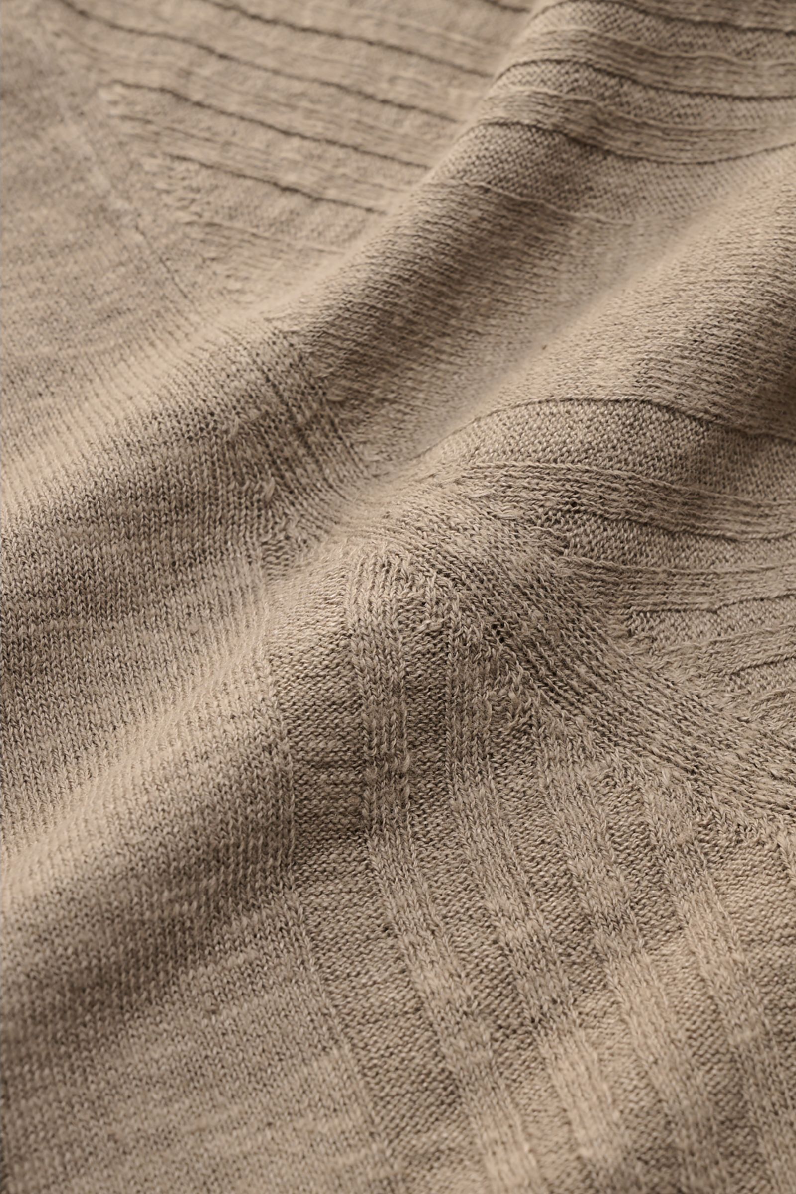 Nahaufnahme des feinen Strickbilds und des dezenten Strukturstrick-Streifenmusters des taupefarbenen 04651/ A trip in a bag Kurzarm-Strickpolo 'Johnny' aus Leinen-Baumwoll-Mix, fotografiert aus schräger Perspektive.