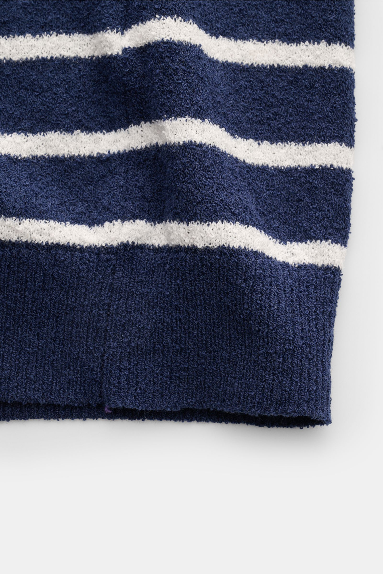Nahaufnahme vom unteren Saum des Circolo 1901 Frottee-Kurzarm-Strickpolo navy/weiß gestreift, mit schmalen weißen Streifen auf navyblauem Frottee-Strick, weiche Baumwolle und Microfaser, materialtypische Struktur, leicht körniger Griff, flexible Rippbündc
