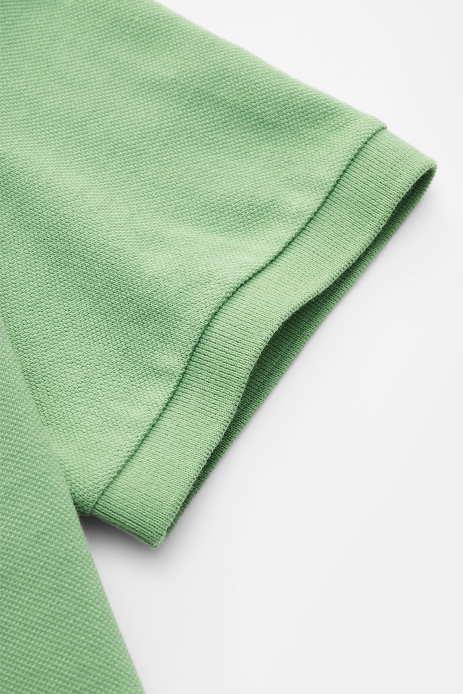 Nahaufnahme des mintgrünen Polo Ralph Lauren Poloshirts von schräg oben, zeigt fein strukturierte Piqué-Baumwolle und elastisches Ärmelbündchen.