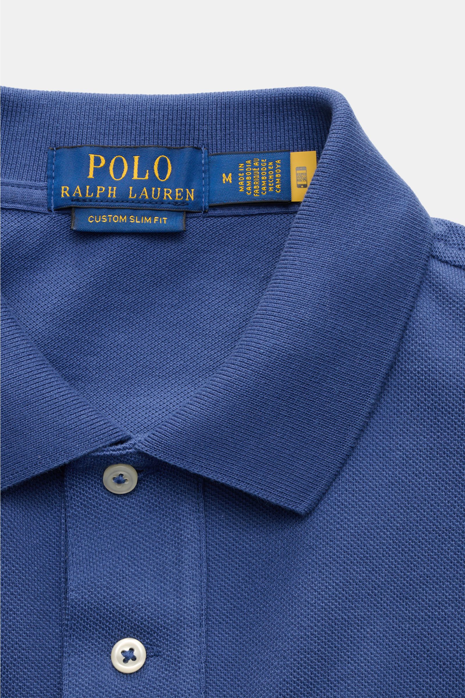 Nahaufnahme aus oben auf das Polo Ralph Lauren Poloshirt blau, klassischer Polokragen, Zwei-Knopf-Leiste, reine Baumwolle, feine Piqué-Struktur, Slim Fit.