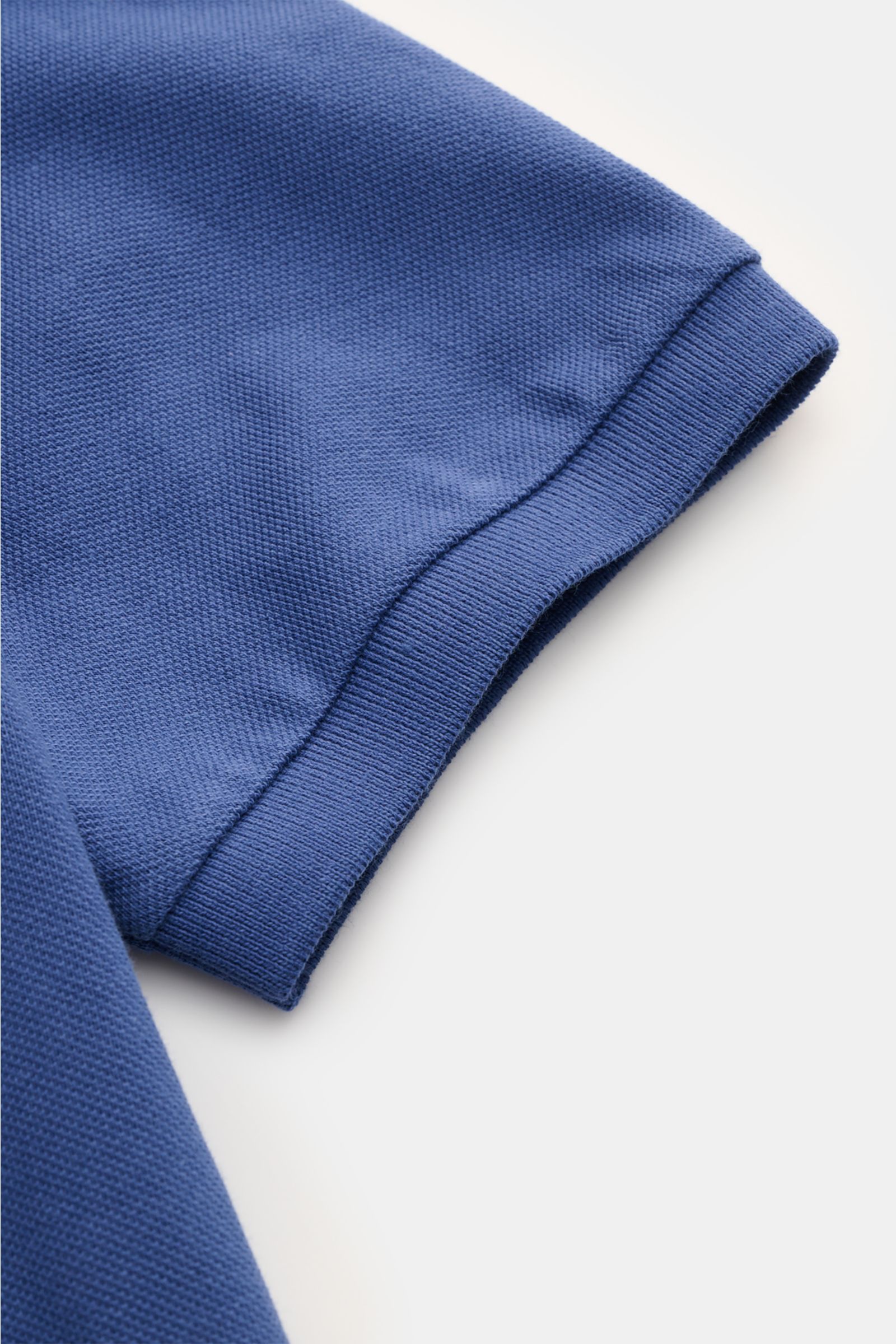 Nahaufnahme des Ärmels vom Polo Ralph Lauren Poloshirt blau, feine Piqué-Struktur, elastisches Bündchen, reine Baumwolle, Slim Fit.