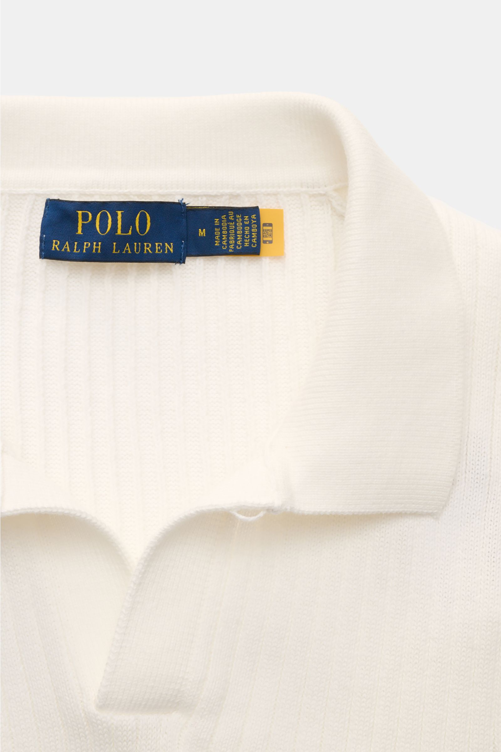 Nahaufnahme aus schräger Draufsicht auf das Offwhite Polo Ralph Lauren Kurzarm-Strickpolo aus reiner Baumwolle mit klassischem Polokragen, variabler Knopfleiste und feinem Rippstrick.
