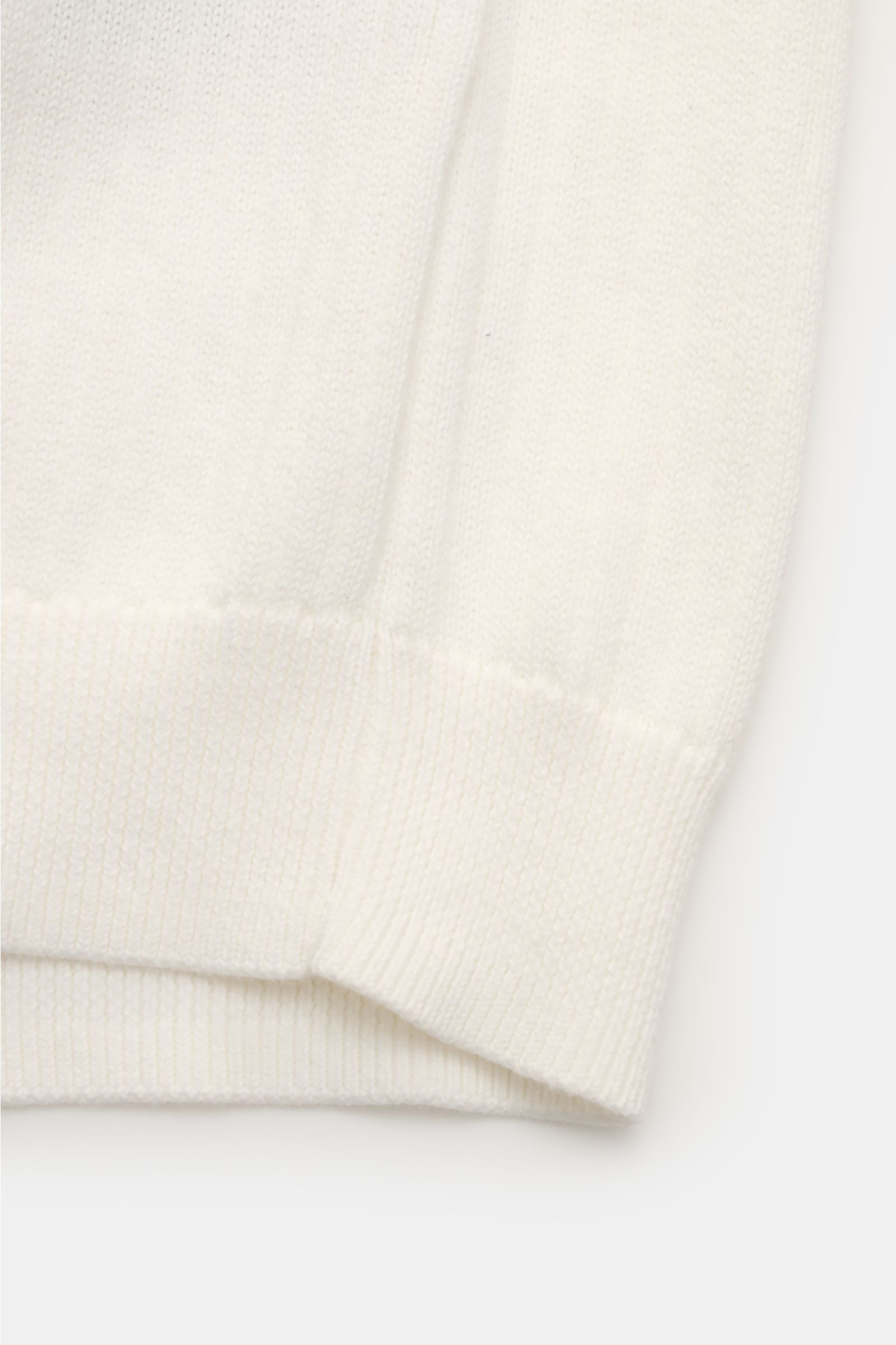 Nahe Aufnahme des Polo Ralph Lauren Kurzarm-Strickpolo offwhite in Rippstrick-Optik, zeigt elastische Rippbündchen und weichen Griff.
