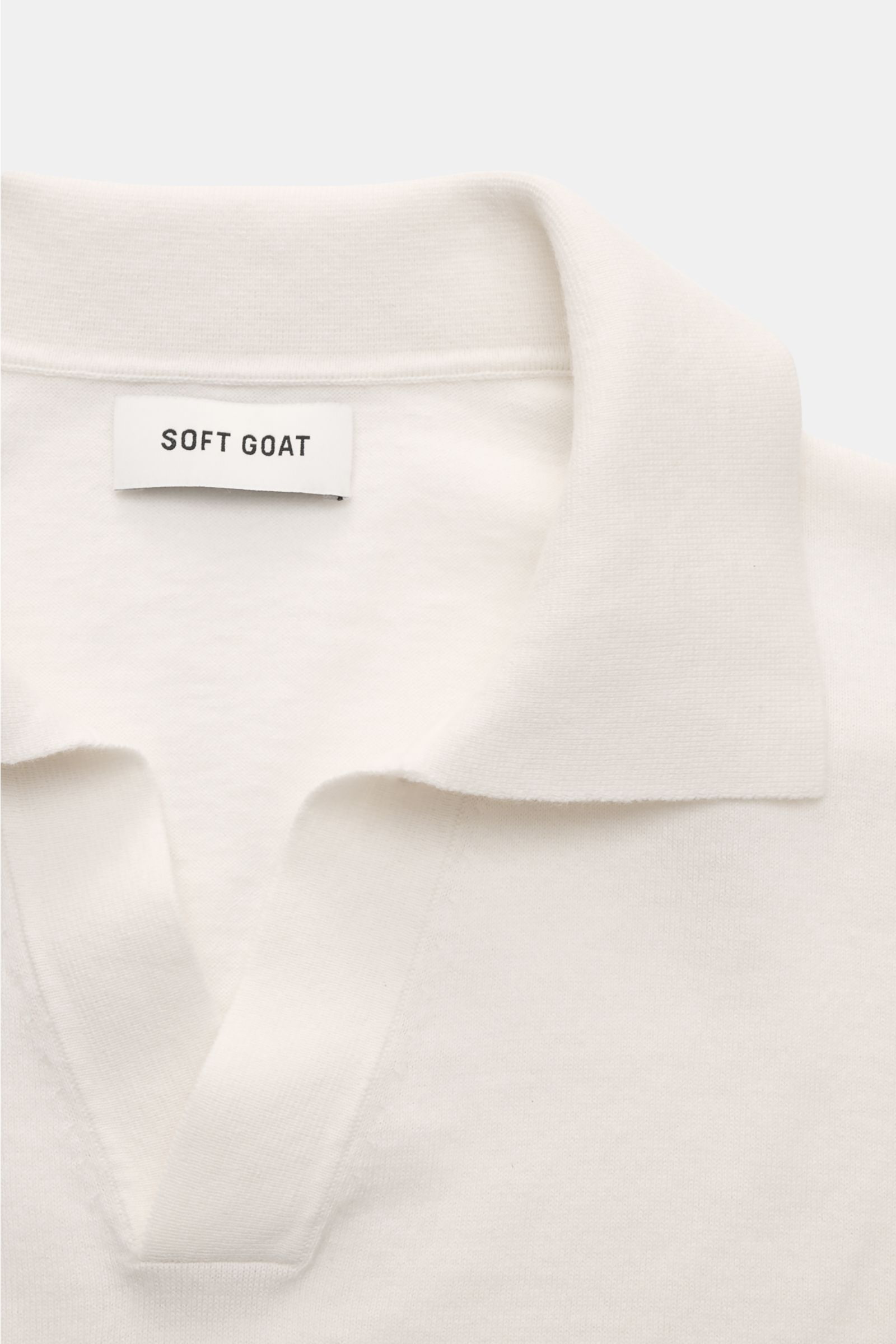 Soft Goat Kurzarm-Strickpolo offwhite aus Baumwolle und Cashmere, Slim Fit, gestrickter Polokragen, offene Kragenleiste, flexible Rippbündchen, Detailaufnahme von oben.