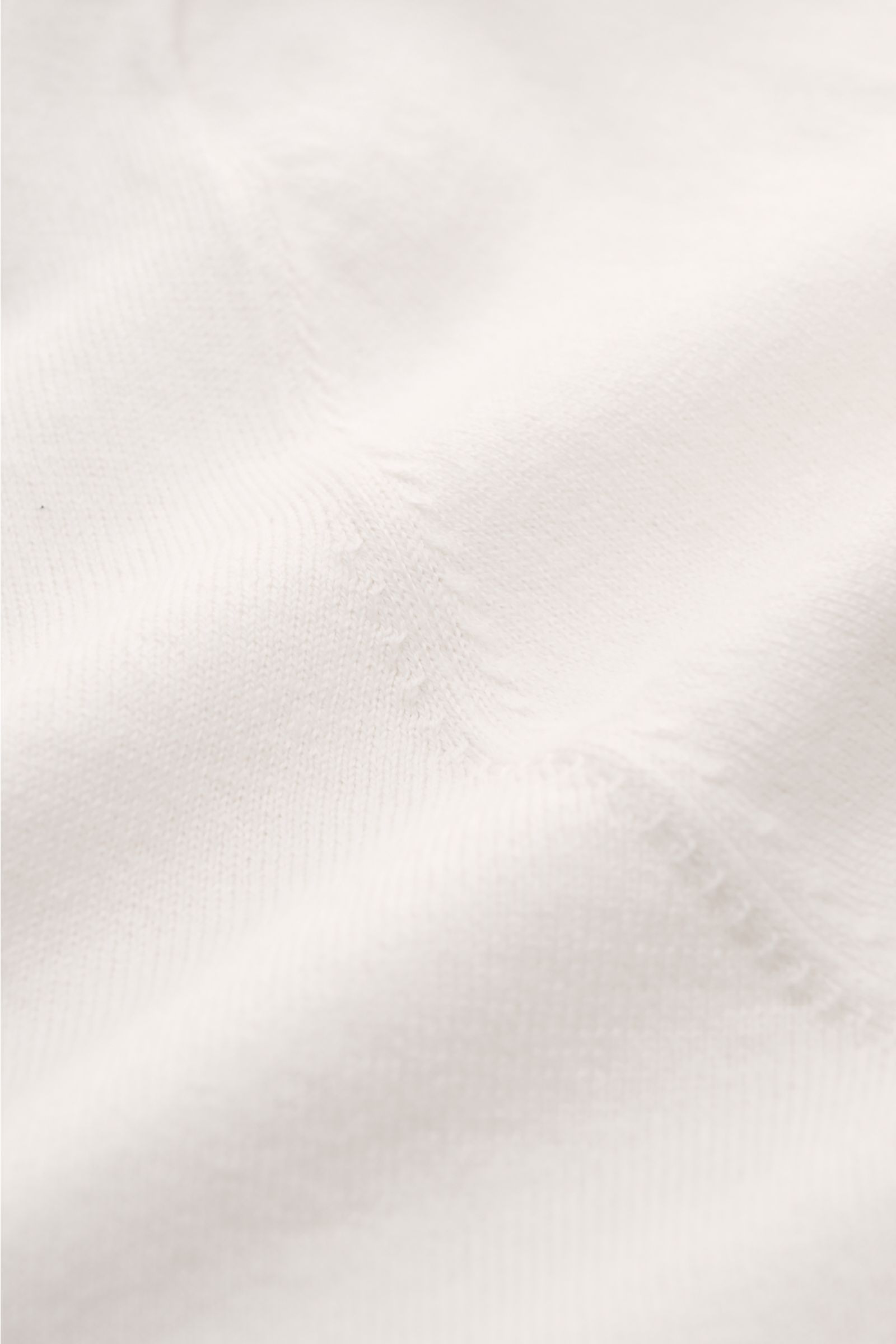 Soft Goat Kurzarm-Strickpolo offwhite aus Baumwolle und Cashmere, Slim Fit, gestrickter Polokragen, offene Kragenleiste, flexible Rippbündchen, Detailaufnahme Material.