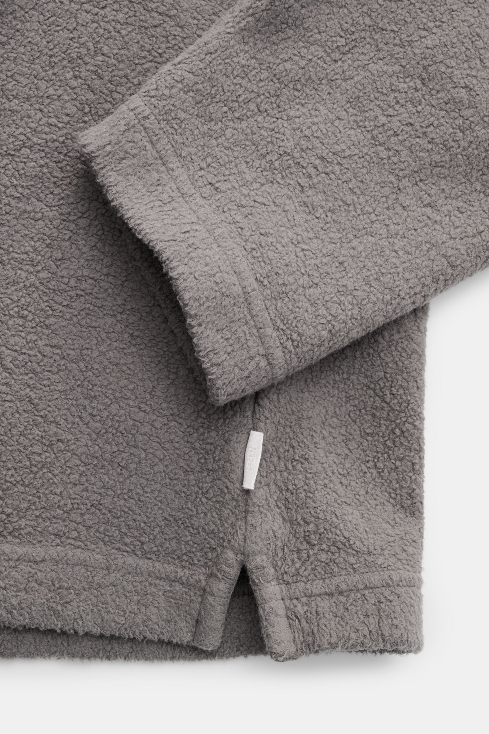 Detailaufnahme von Ärmel und Saum mit kurzem Schlitz des 04651/ A trip in a bag Fleece Langarm-Poloshirt dunkelgrau, fleece aus reiner Baumwolle, softer Griff, garment dyed, Regular Fit, typischer Polokragen, Drei-Knopf-Leiste, kleines Weblabel in der Sei