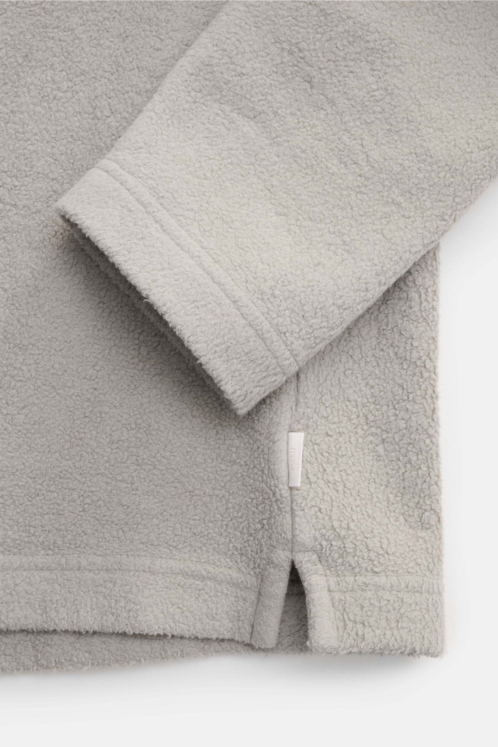 04651/ A trip in a bag Fleece Langarm-Poloshirt grau, Detailaufnahme von Ärmel und Saum mit kurzen Saumschlitzen, Fleece aus reiner Baumwolle, softer Griff, garment dyed, Regular Fit, typischer Polokragen, Drei-Knopf-Leiste, kleines Weblabel in der Seiten