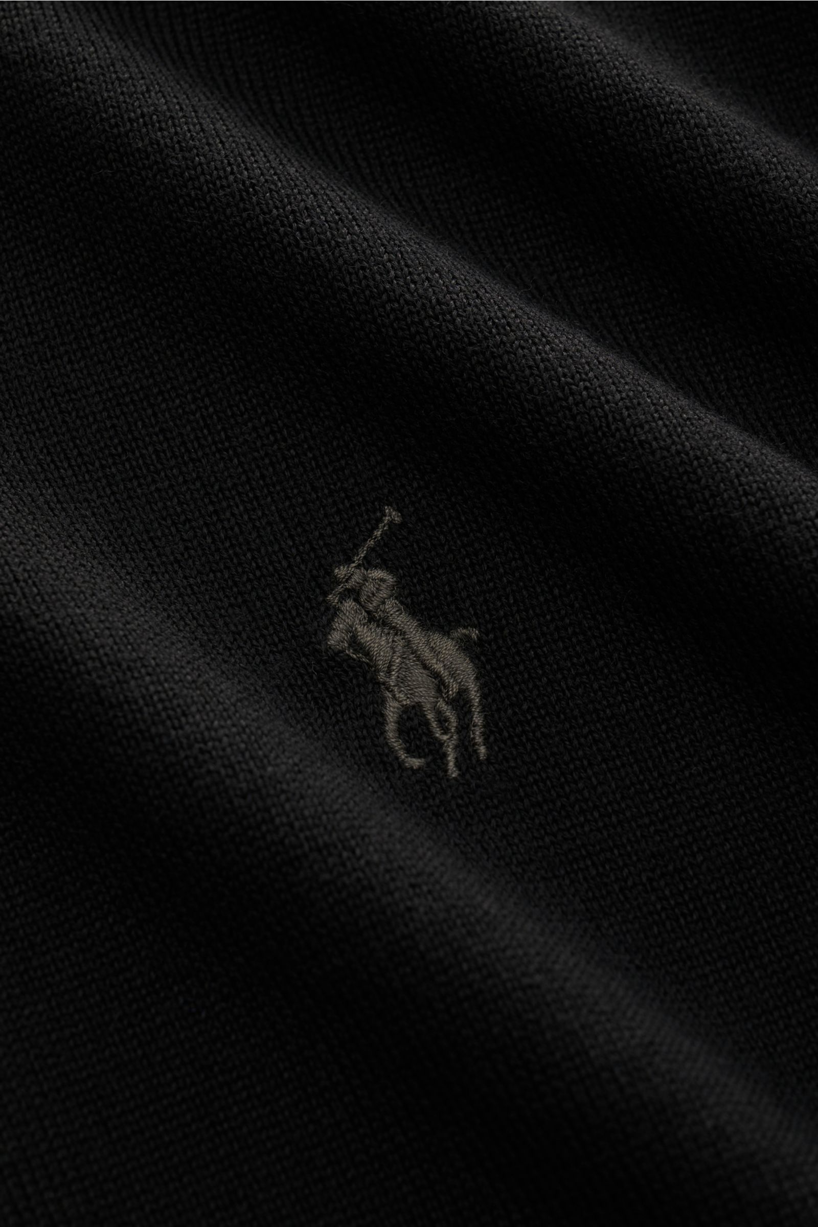 Close-up front view of Polo Ralph Lauren Strickpolo schwarz showing fine knit wool fabric and embroidered logo, slim fit.

Mit diesem exklusiven Strickpolo aus reiner Wolle bietet POLO RALPH LAUREN ein Basic-Piece für viele Gelegenheiten.

