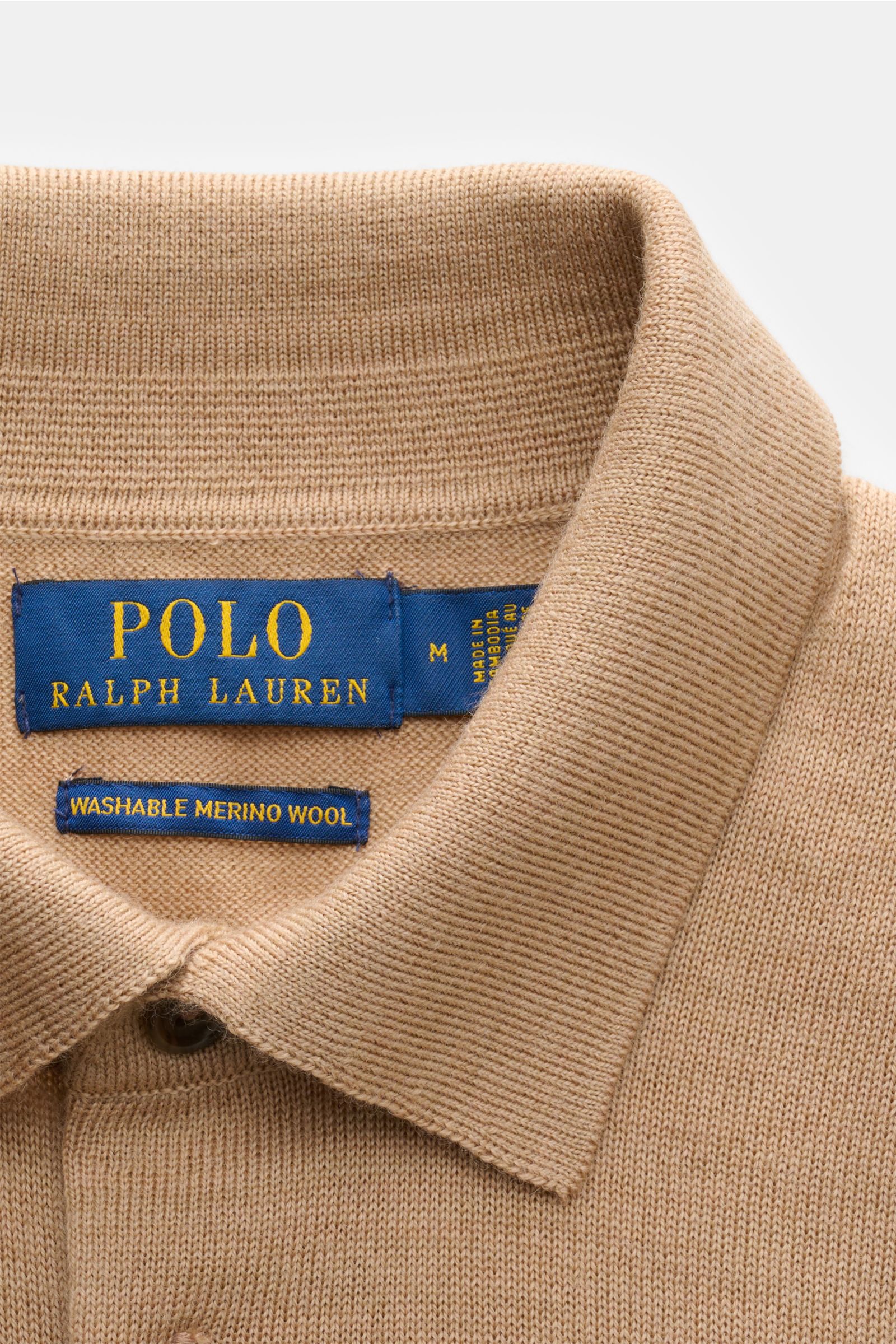 Beige Polo Ralph Lauren Strickpolo aus reiner, weicher Wolle mit feinem Strickbild, Slim Fit, Polokragen und Drei-Knopf-Leiste, Nahaufnahme von oben.